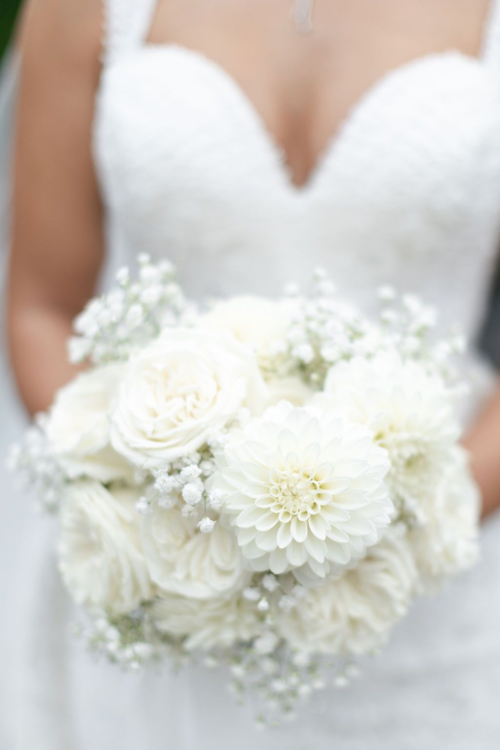 Bride holding all white minimal floral bouquet