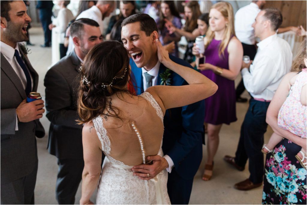 Wedding guests enjoying a lively celebration inside a rustic venue.