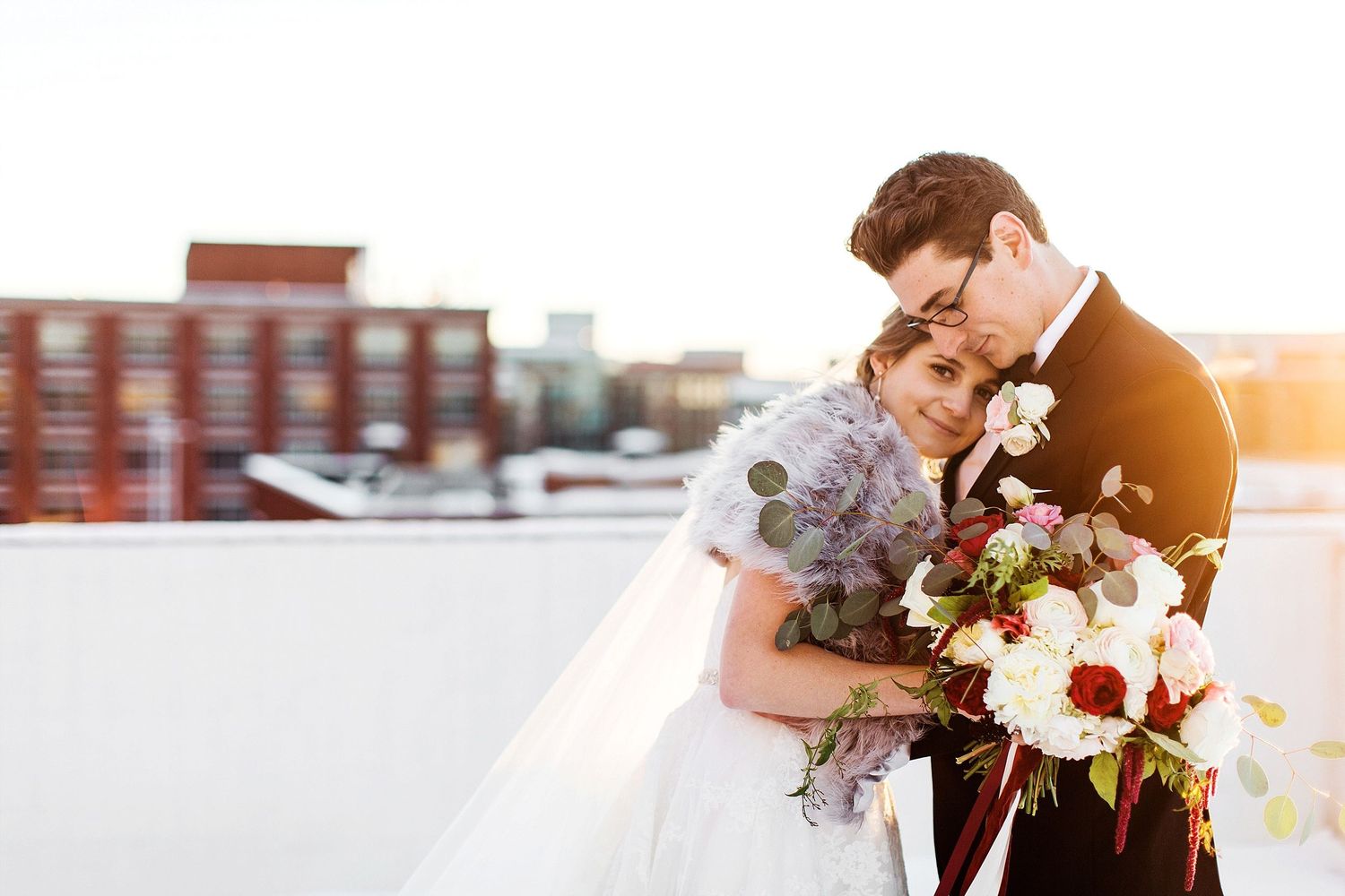 A romantic rooftop moment at sunset with elegant wedding florals.