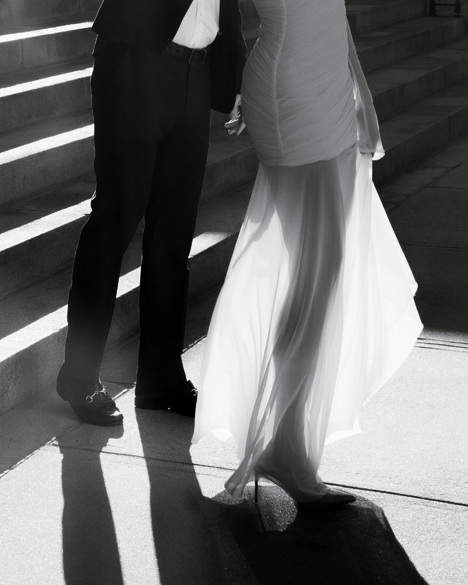 Black and white image sequence showing feet of a couple dancing together, with the woman wearing a white dress.