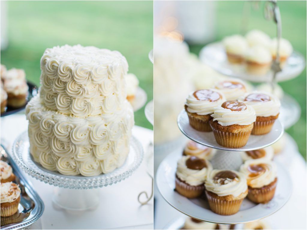 A white wedding cake with delicate rose swirl details next to tiered cupcake displays.