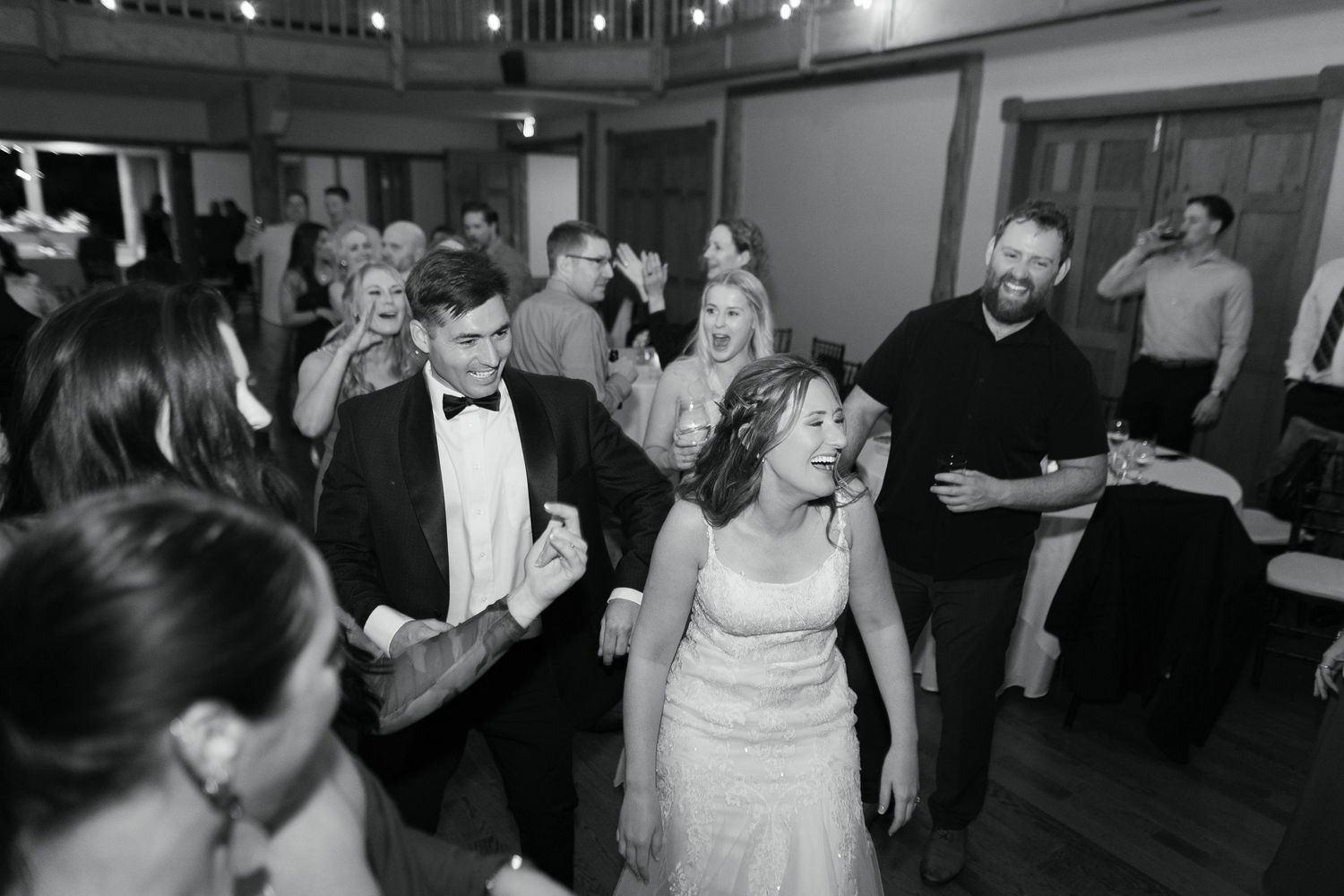 Wedding reception guests dancing together on the dance floor during a black and white celebration.