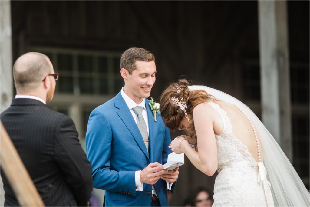 A joyful wedding ceremony moment under a covered outdoor pavilion with natural lighting.