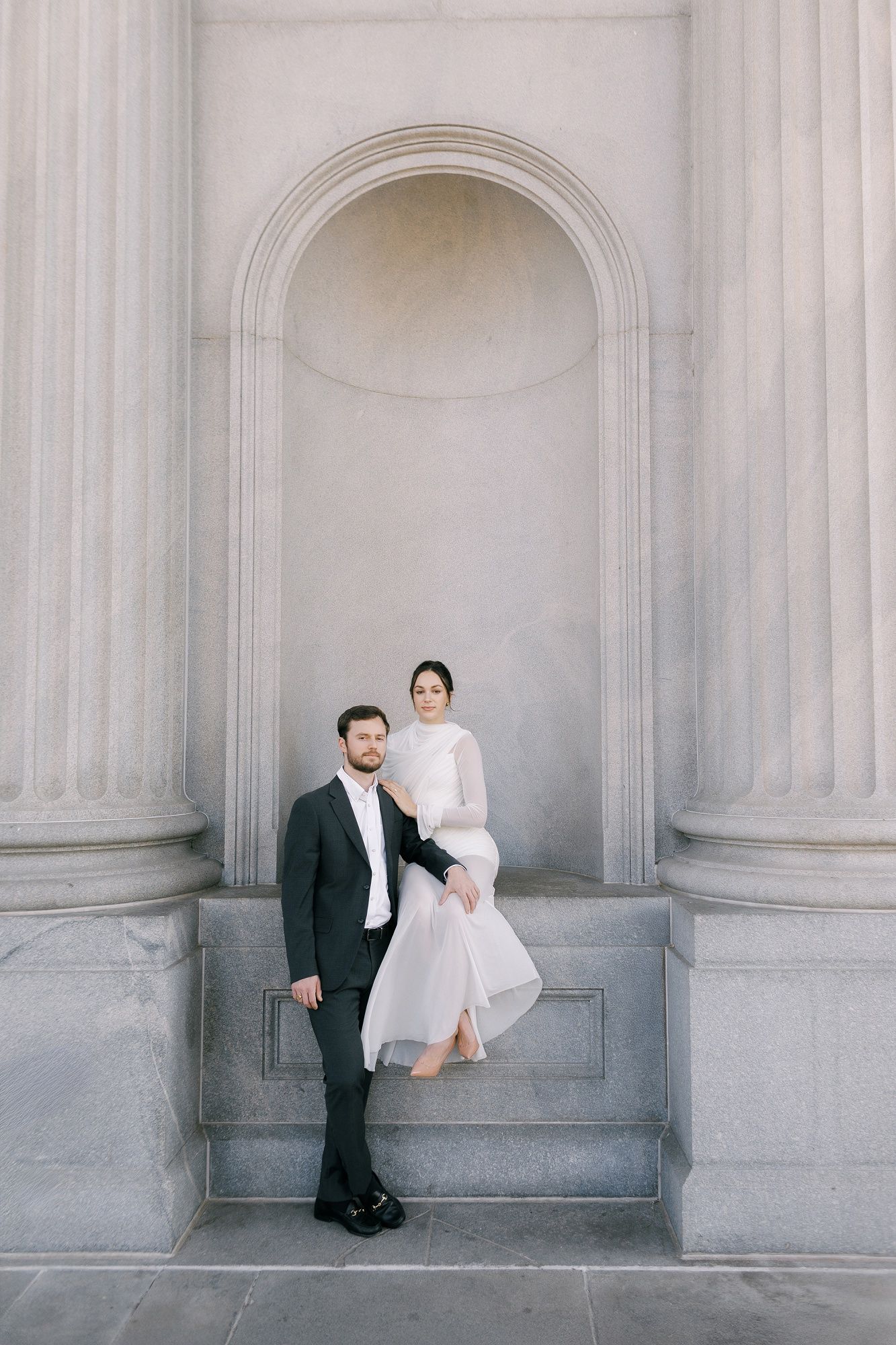 A wedding couple poses creatively in a series of four artistic photos against white stone columns.
