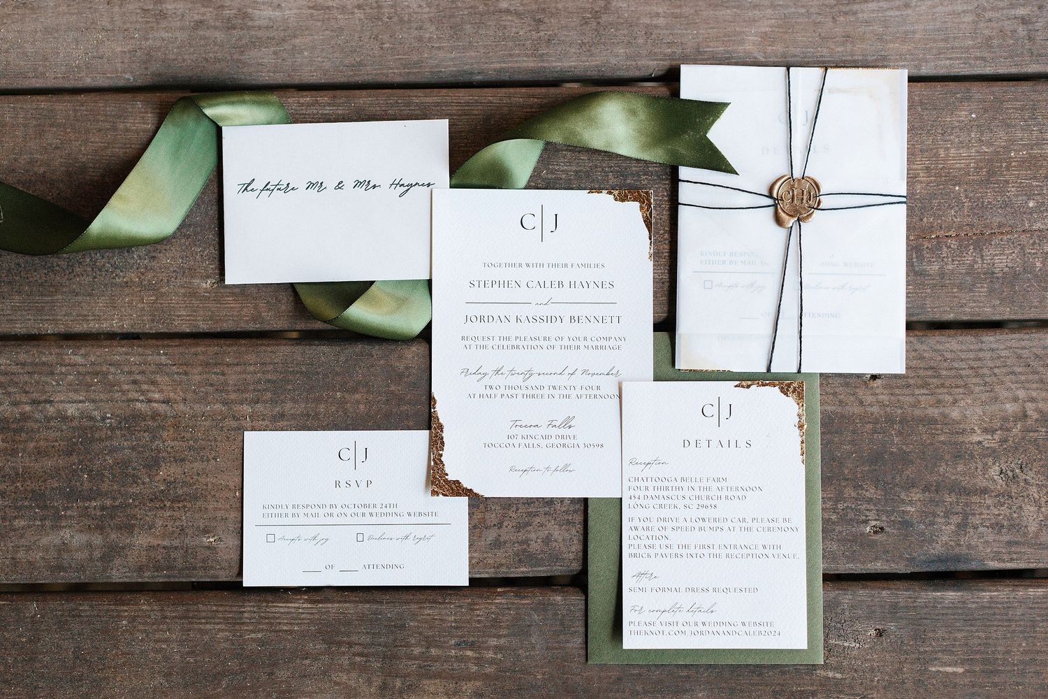 Elegant wedding invitation suite with sage green ribbon and wax seal displayed on rustic wooden background.