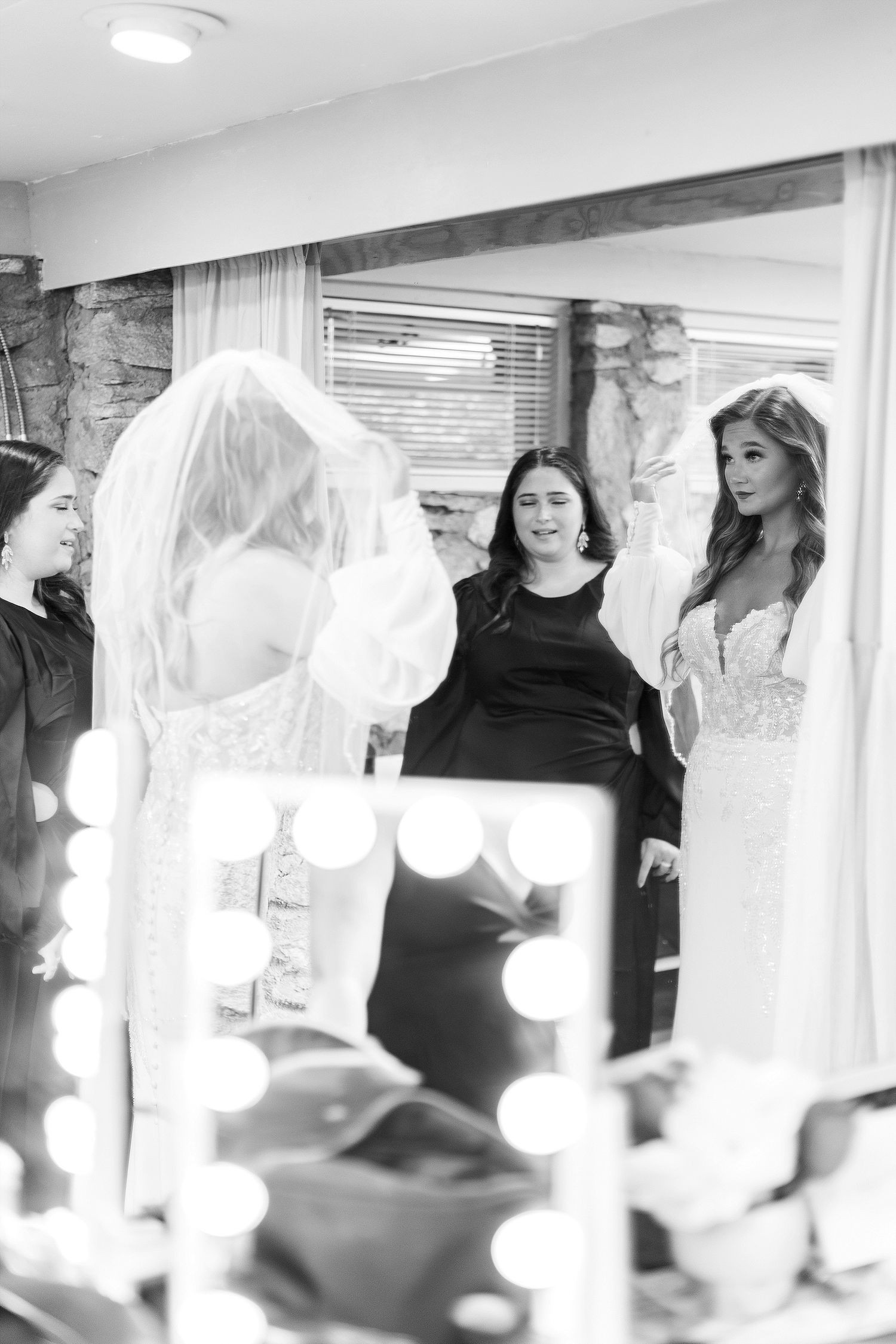 Wedding dress preparation scene with mirror reflections and vanity lights.