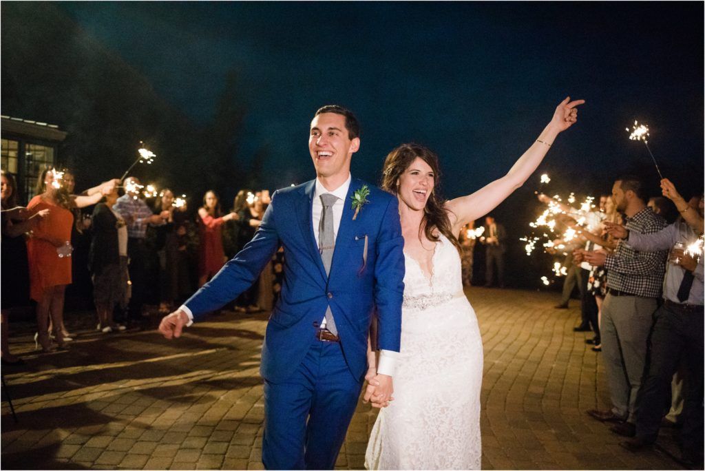 Newlyweds exit through a sparkler send-off under the night sky.