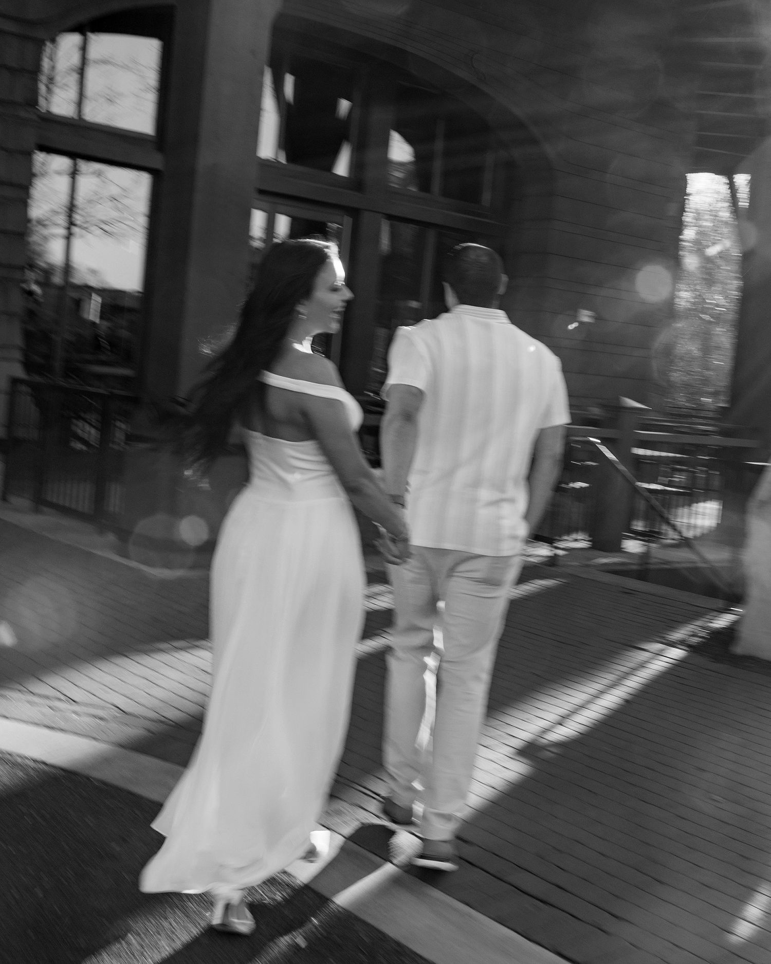 Artistic black and white photo capturing movement of people walking in white clothing.