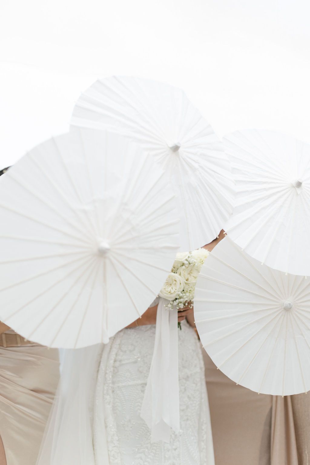 bridal party with white parasols