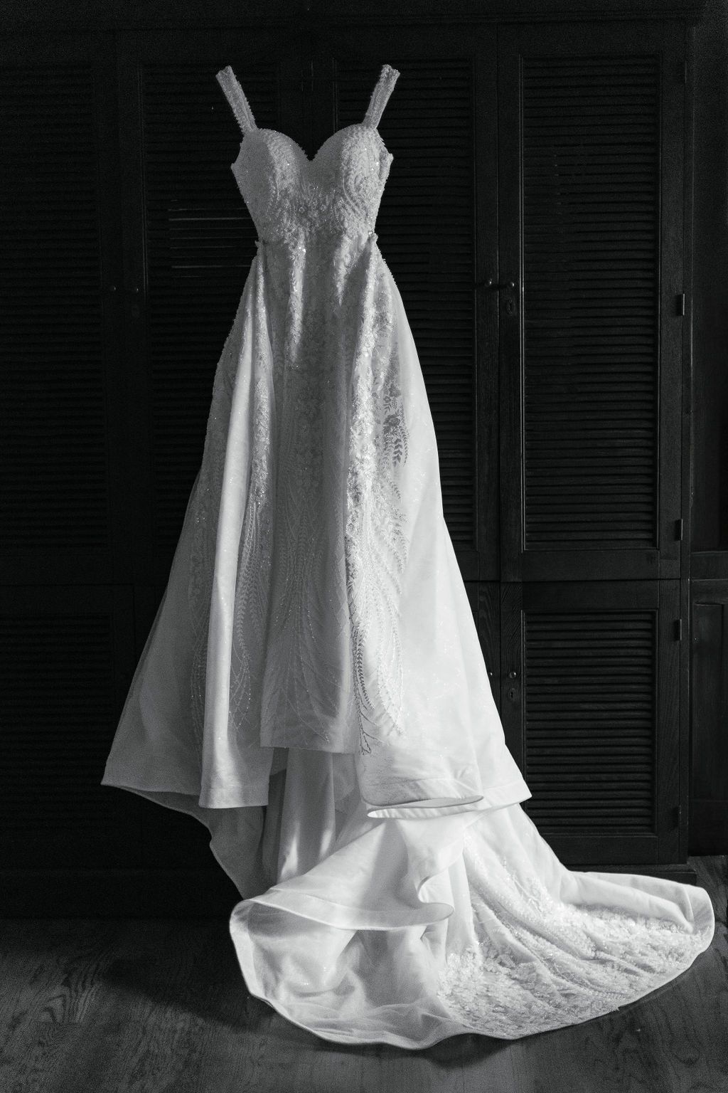 black and white image of wedding gown hanging up at hotel domestique