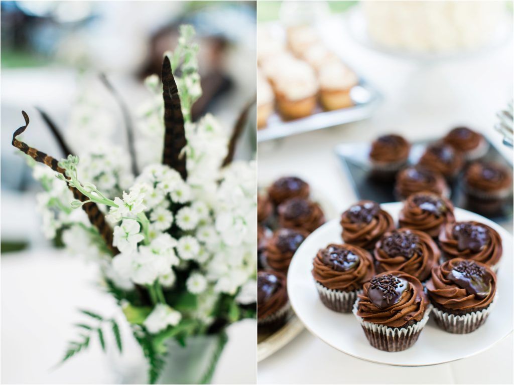 White floral arrangements and chocolate cupcakes with swirled frosting at an elegant event.