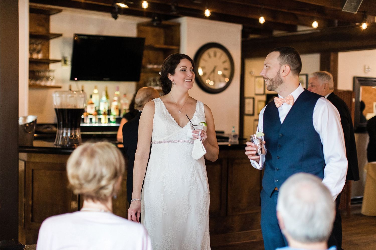 A celebratory toast takes place at a rustic bar venue with exposed beams and vintage decor.