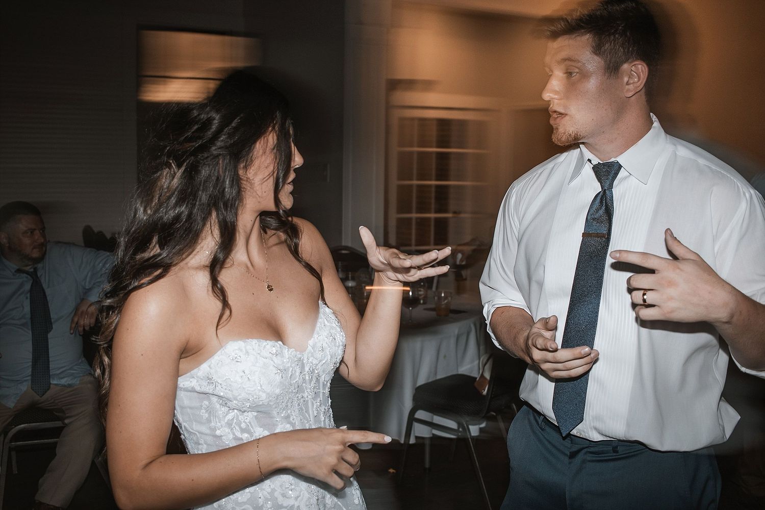 Animated conversation between guests during a lively wedding reception.