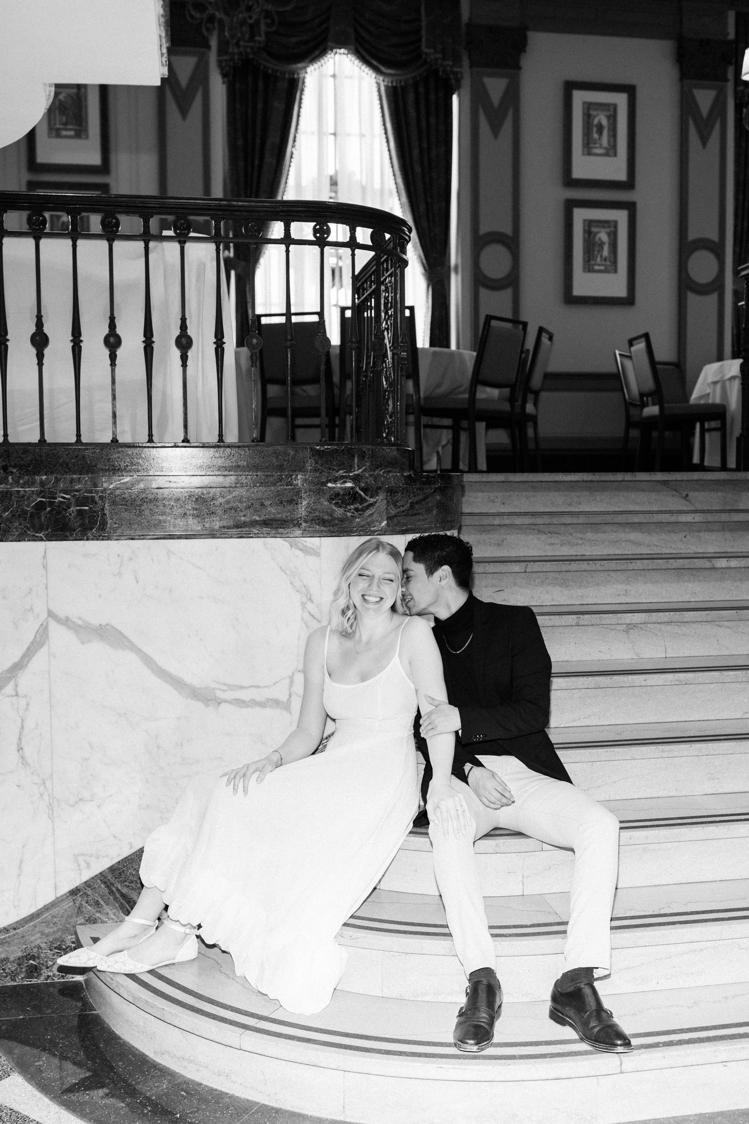 A couple sit on the steps of the Westin Poinsett Hotel's Mezzanine