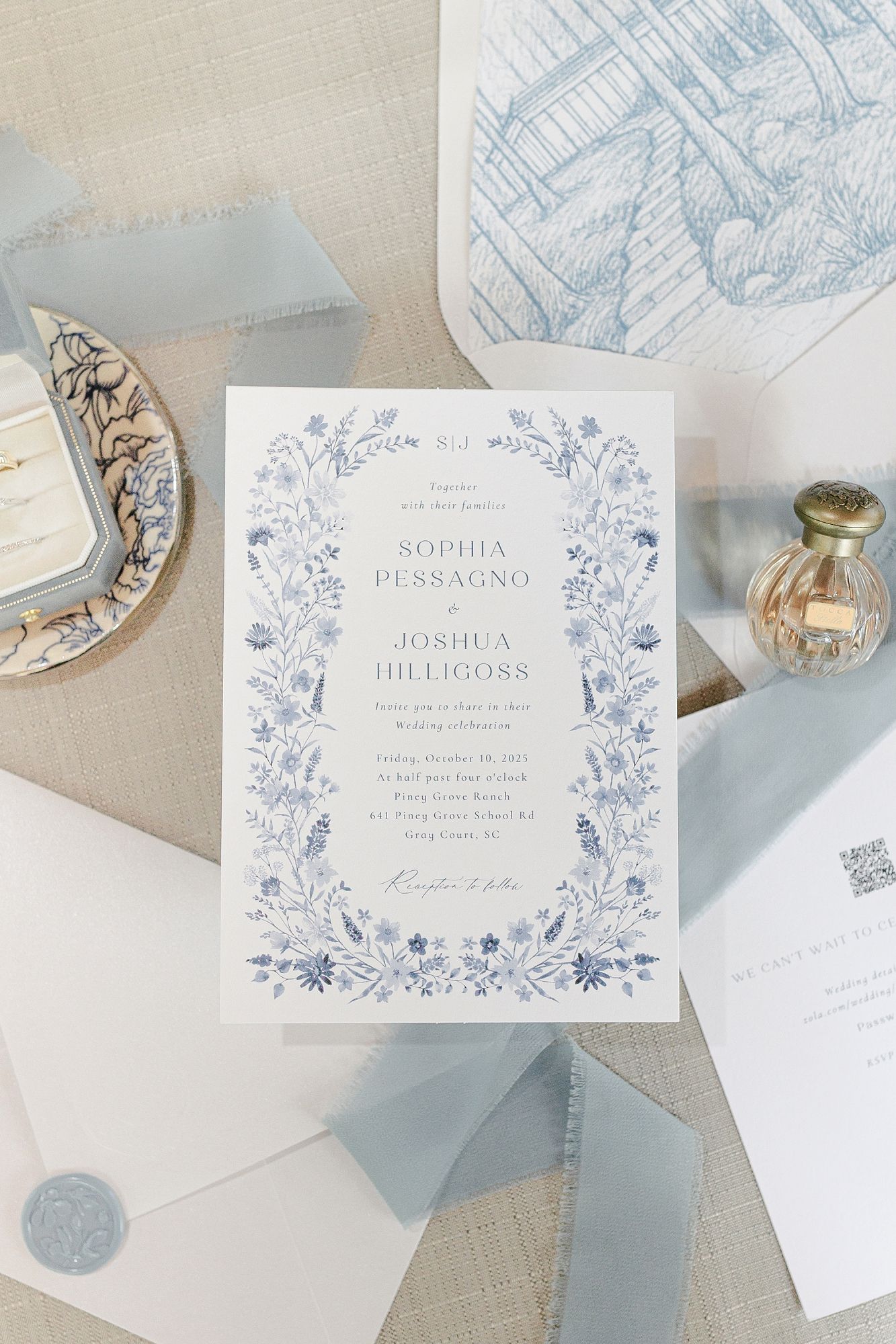 Elegant blue floral wedding invitation suite for Sophia Pessagno and Joshua Hilligoss with wax seal and ribbon accents.