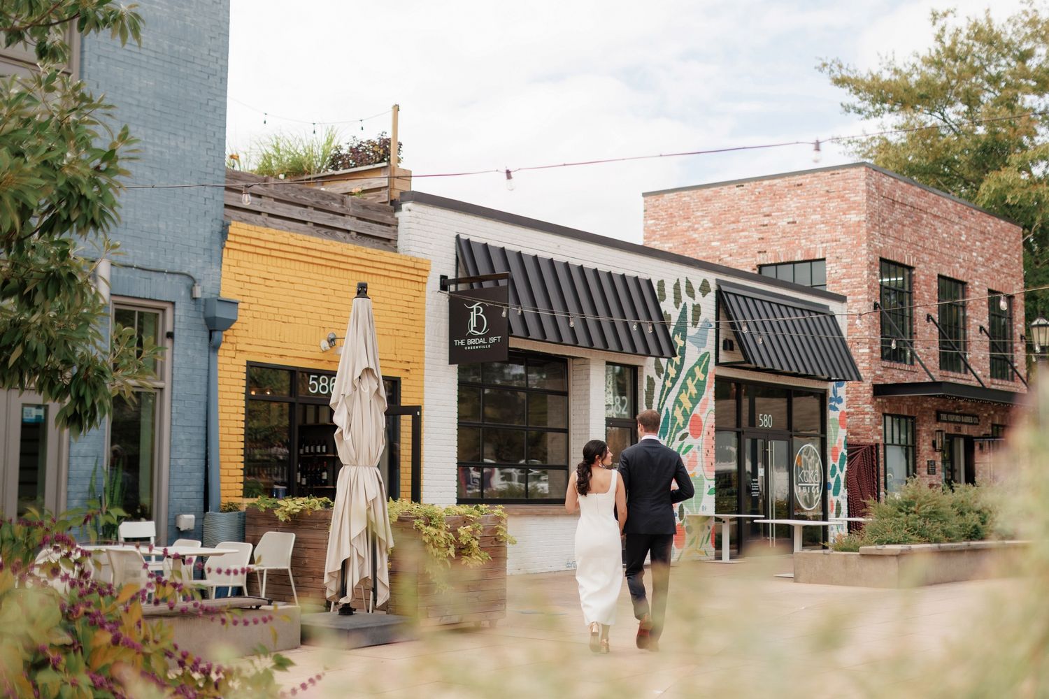 A panoramic view of a small town main street with colorful storefronts and brick buildings on a sunny day.