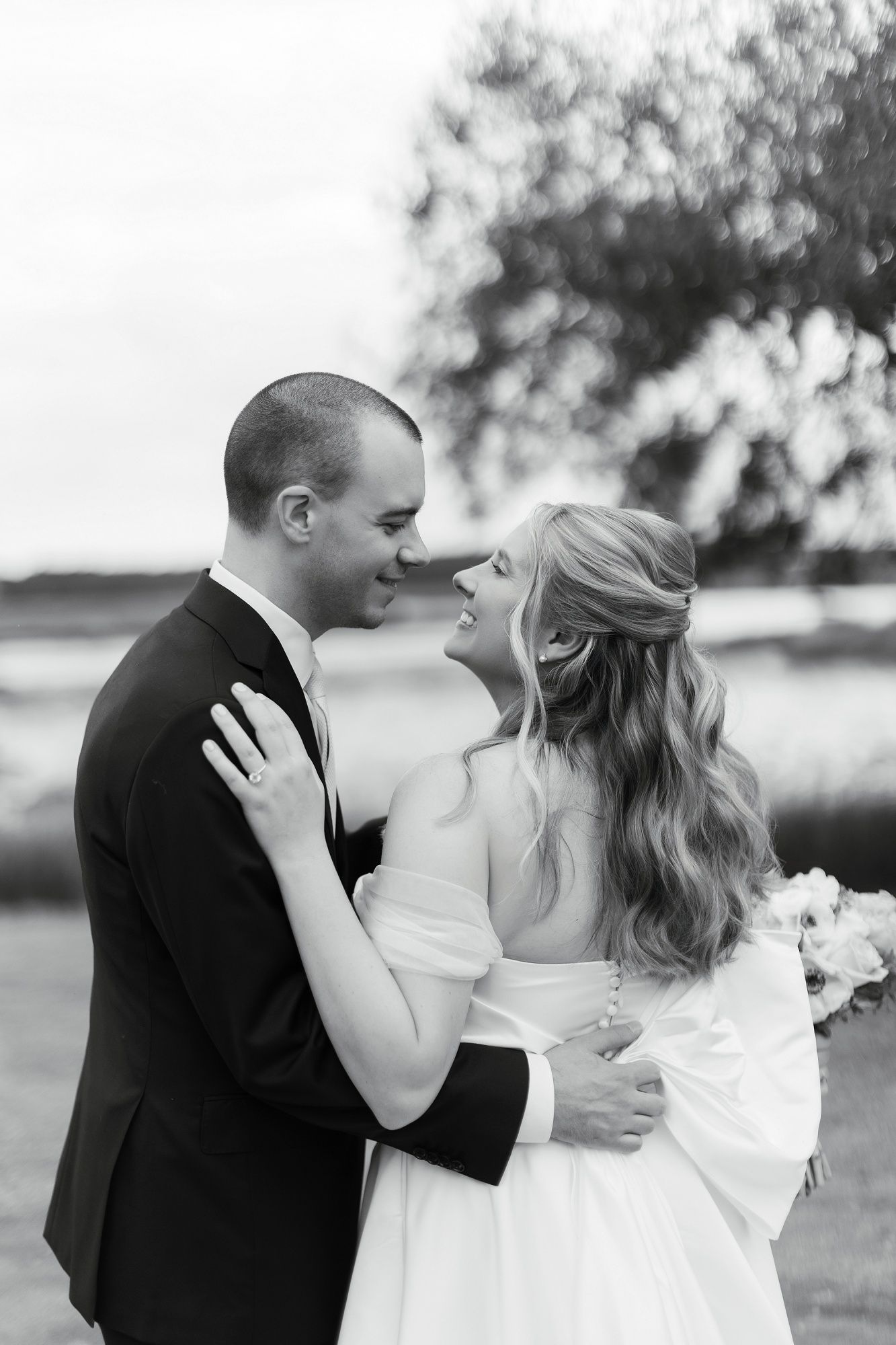 Black and white romantic wedding photos show tender moments between newlyweds in an outdoor setting.