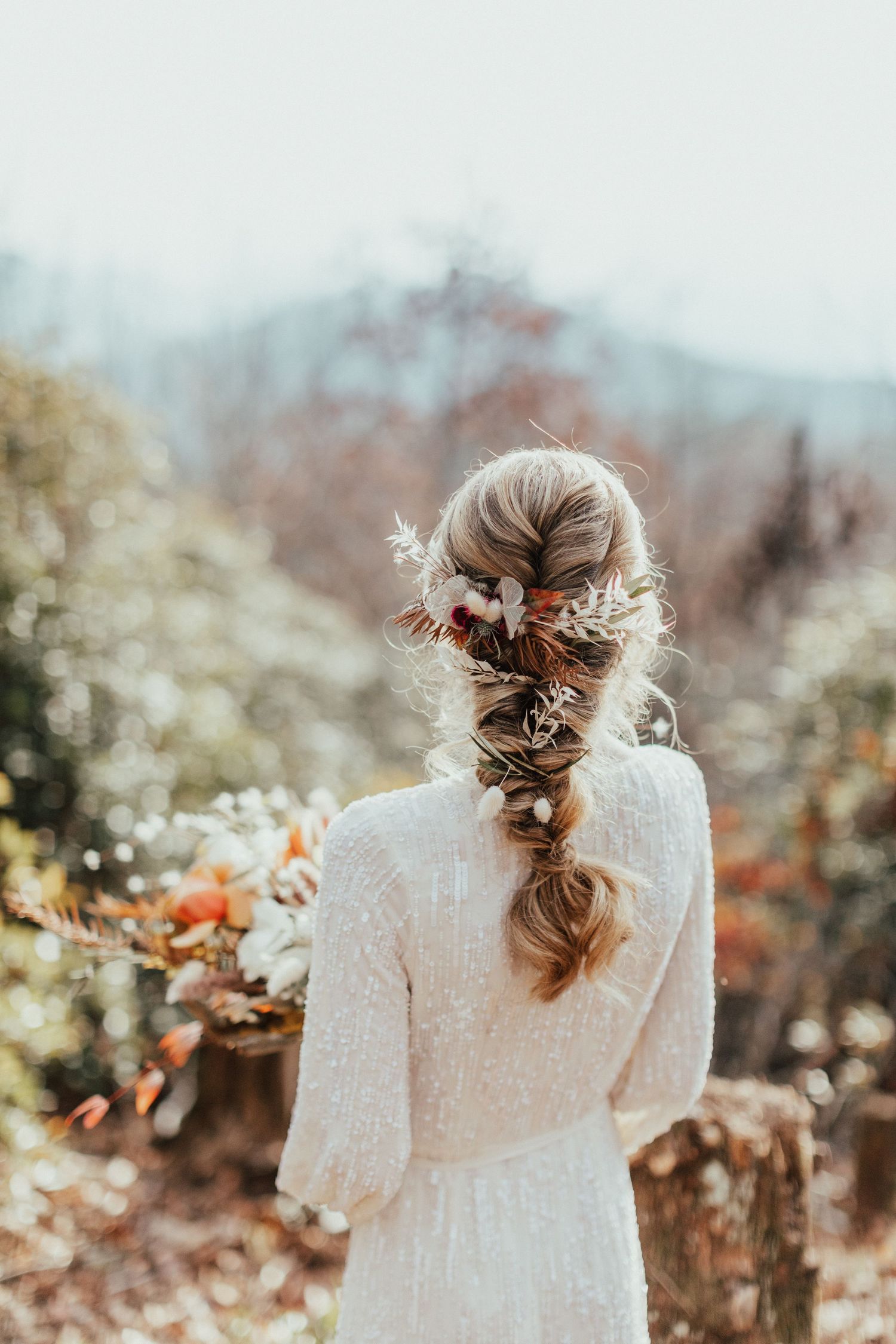 Back view of an intricate bridal hairstyle adorned with delicate floral elements.