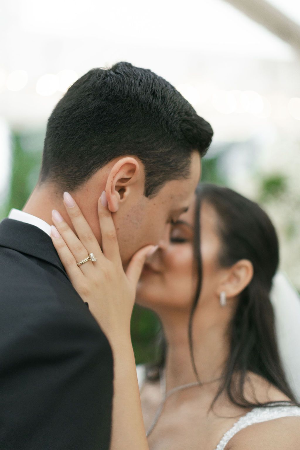 A romantic wedding moment captured as the bride caresses the groom's face during an intimate embrace.