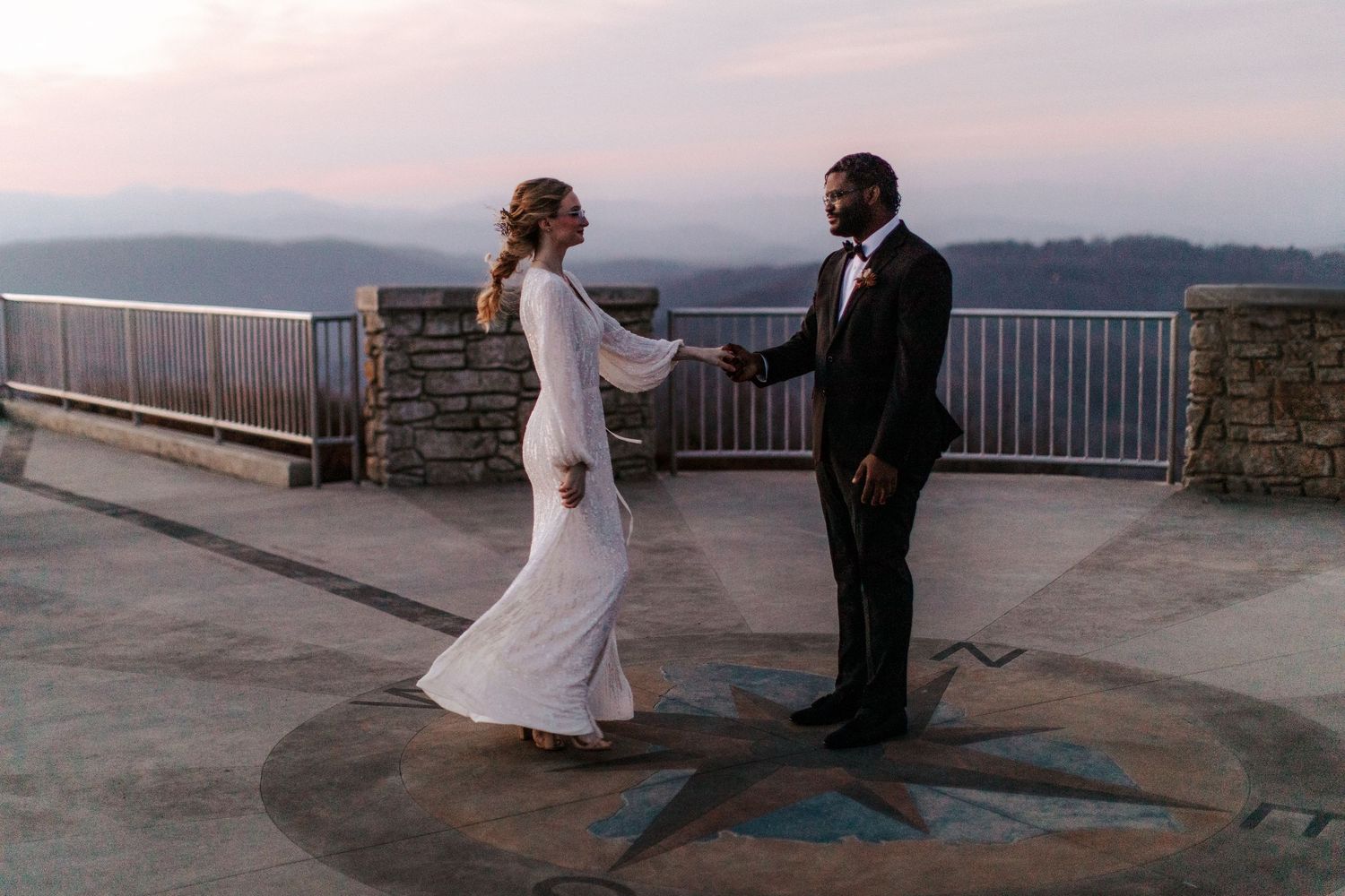 A couple shares a romantic moment at sunset overlooking a scenic mountain vista at Grandfather Mountain.