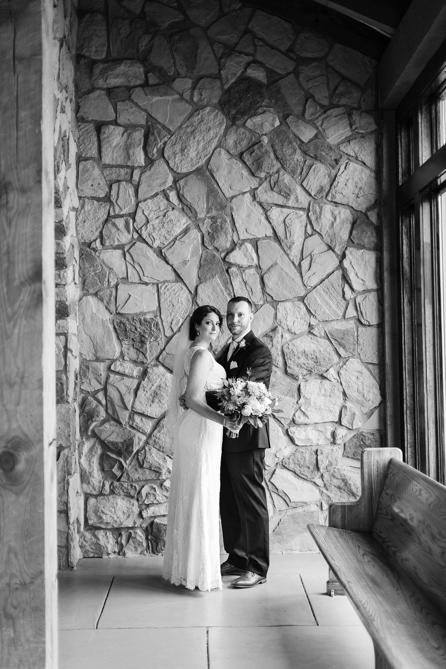 bride and groom with the stonework of Glassy Chapel