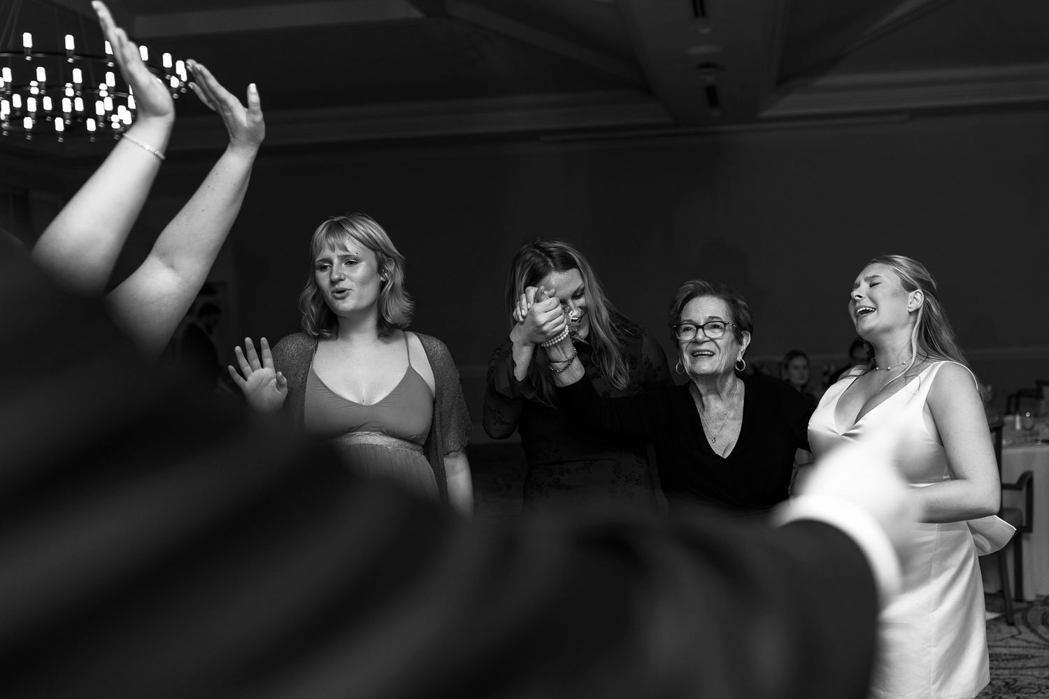 Black and white photos of wedding guests dancing and celebrating at a reception.