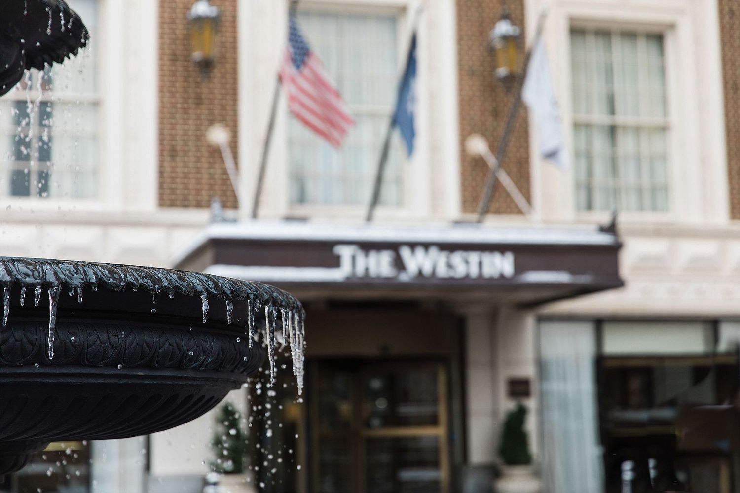 Exterior view of The Westin hotel entrance with icicles hanging from above on a winter day.