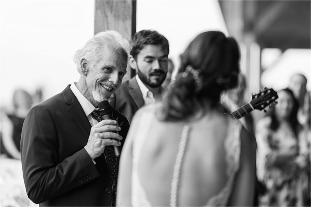A tender moment during a wedding reception as a speaker shares heartfelt words with the bride.