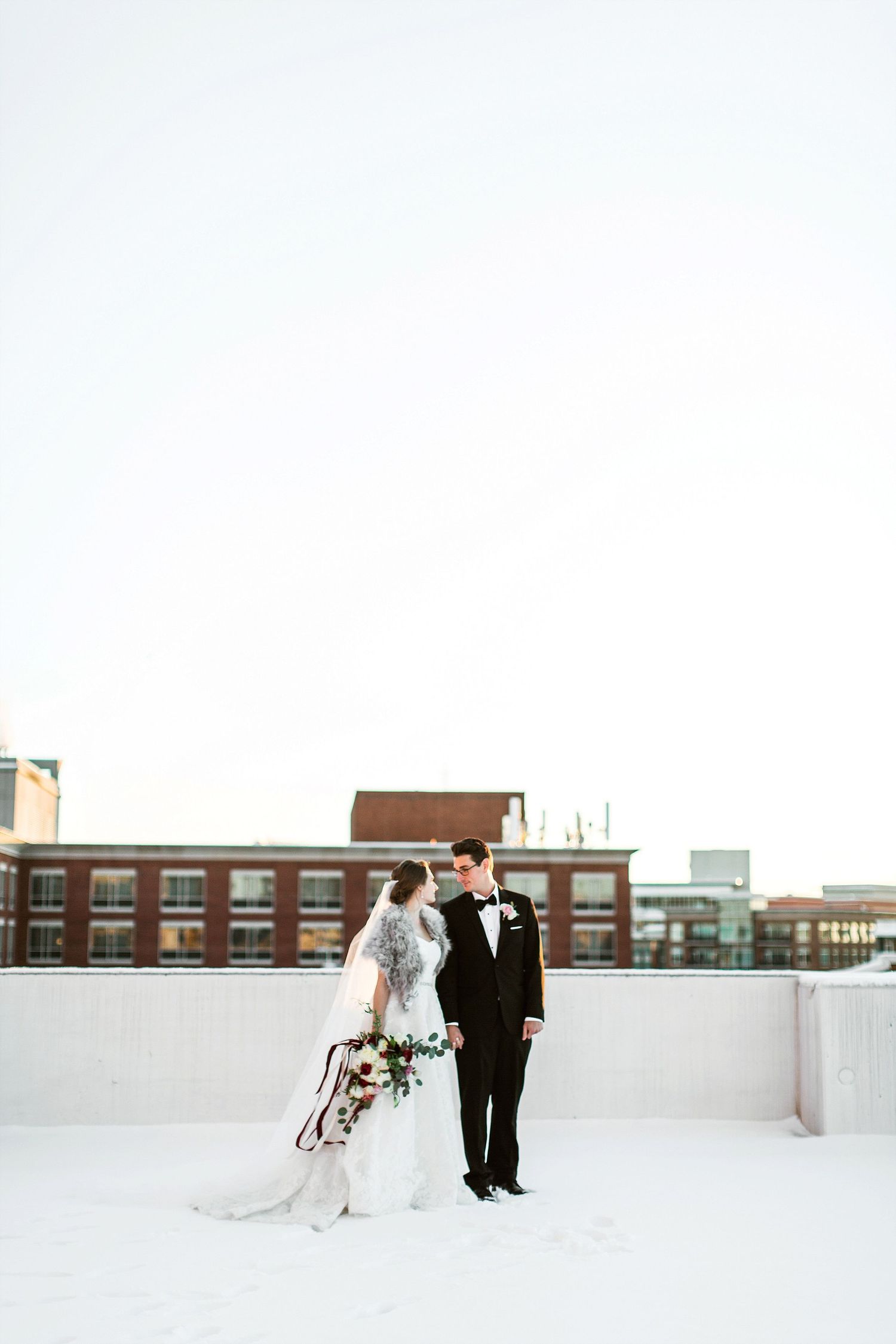Bride and groom wedding portraits at the Westin Poinsett Hotel on a snowy rooftop at sunset