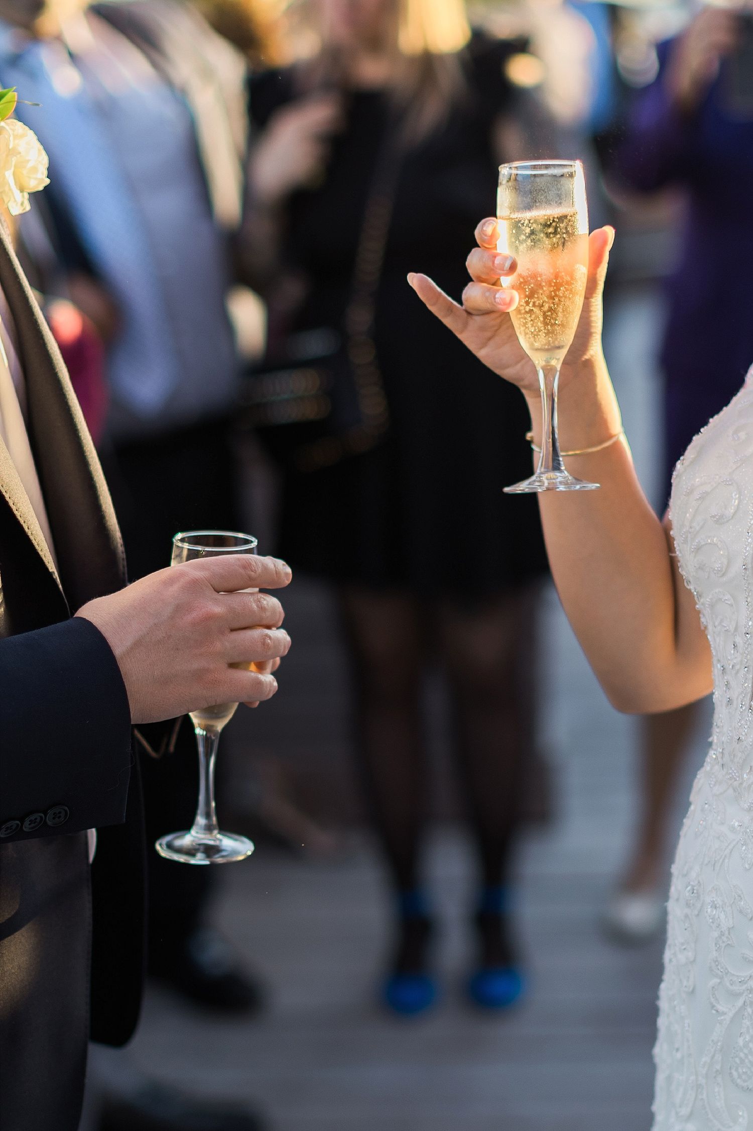 Close-up of champagne glasses being held during a wedding toast.