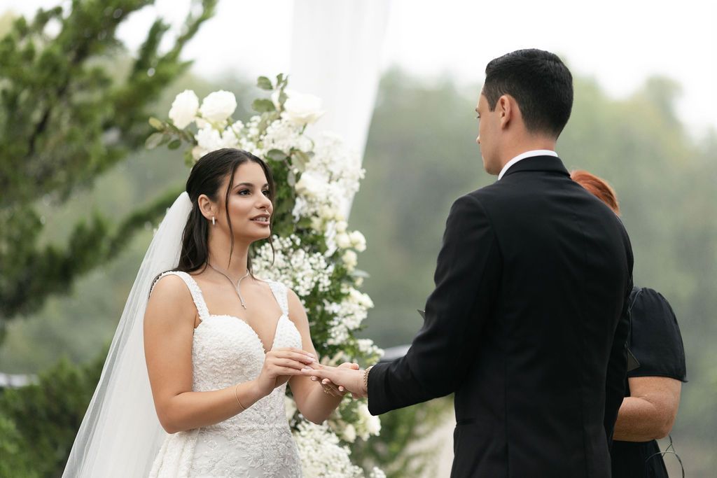 Intimate wedding ceremony moment with white floral decorations.