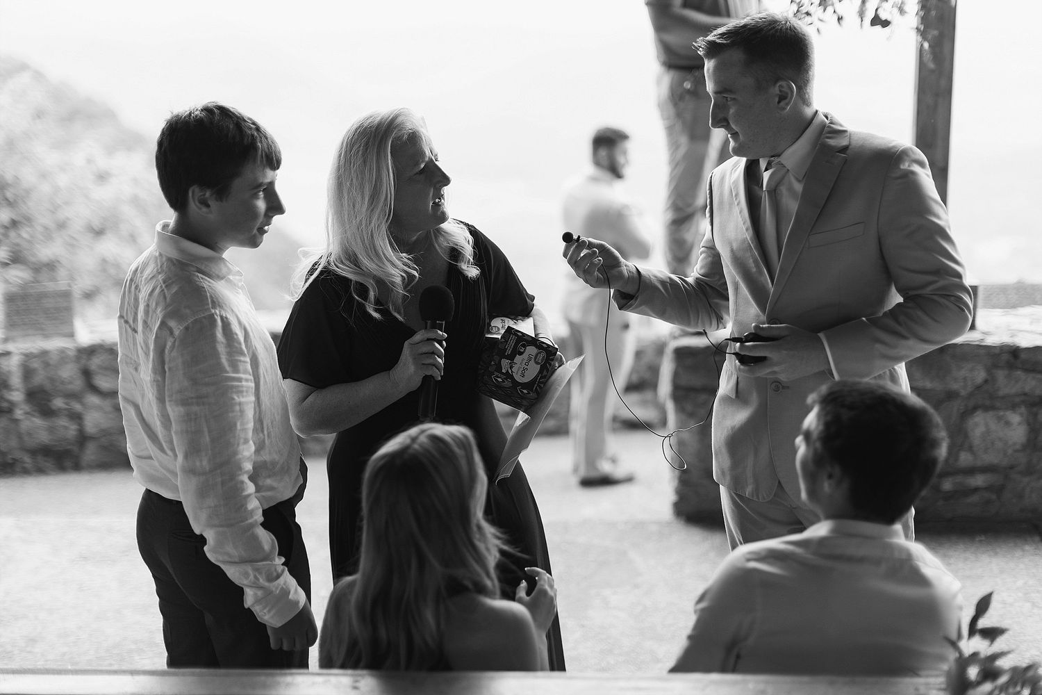 A casual group conversation takes place outdoors during a social gathering in black and white.