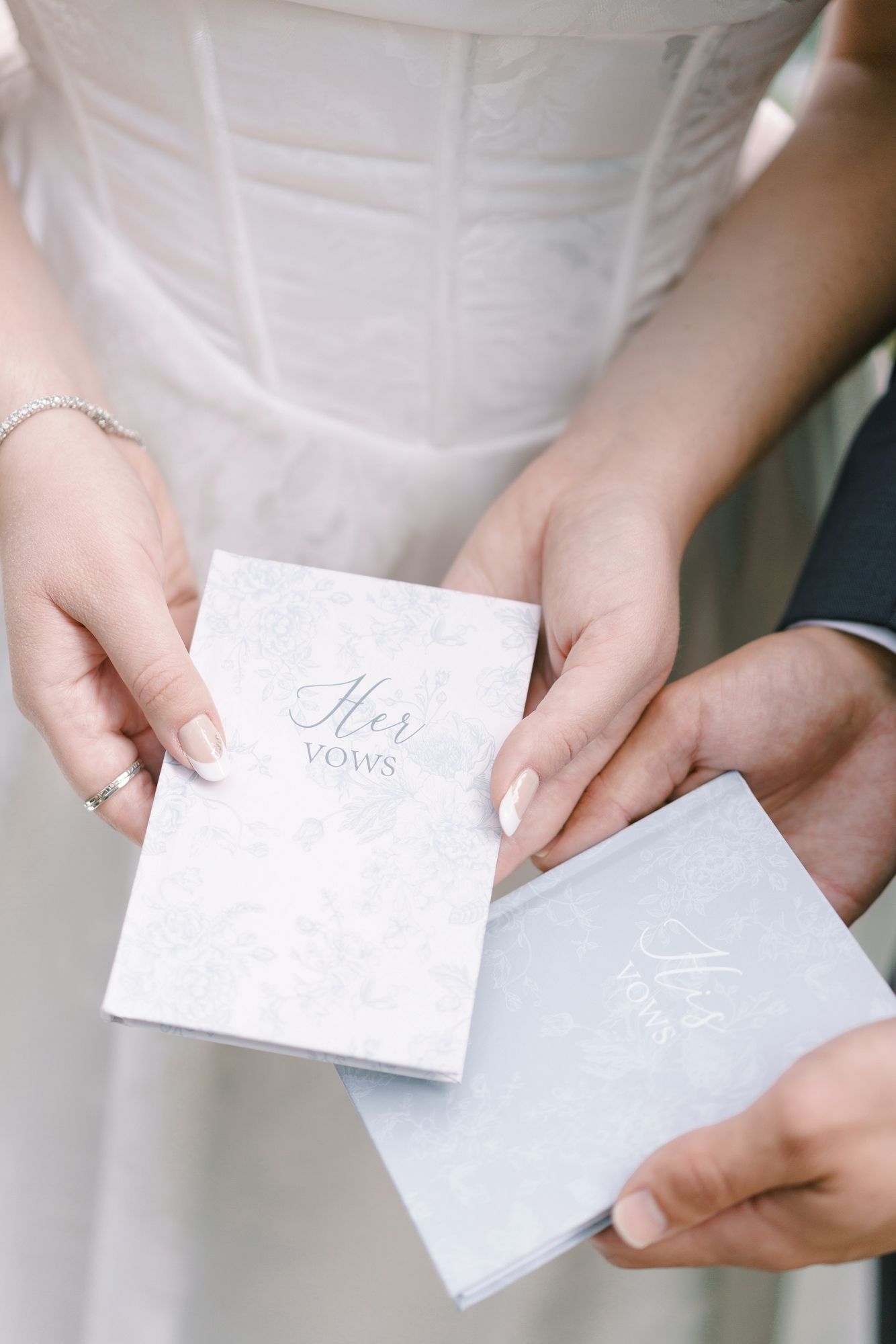 Bride and groom exchanging matching His and Her Vows booklets during wedding ceremony preparation.