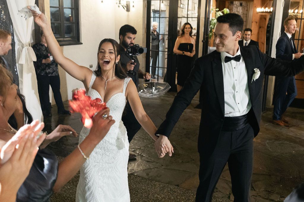 Wedding celebration on dance floor with guests clapping and dancing.