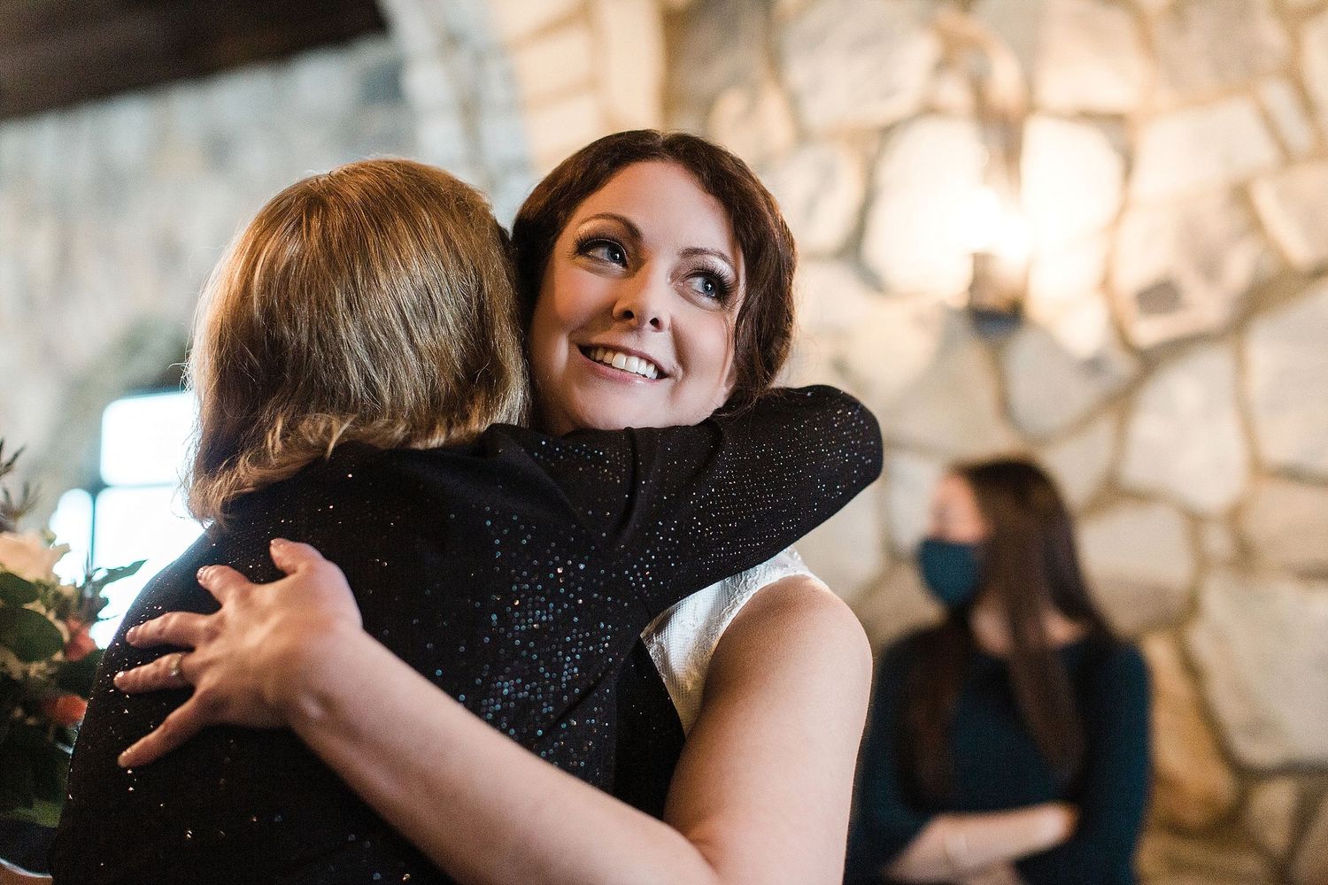Emotional moment captured during wedding reception in stone-walled venue.
