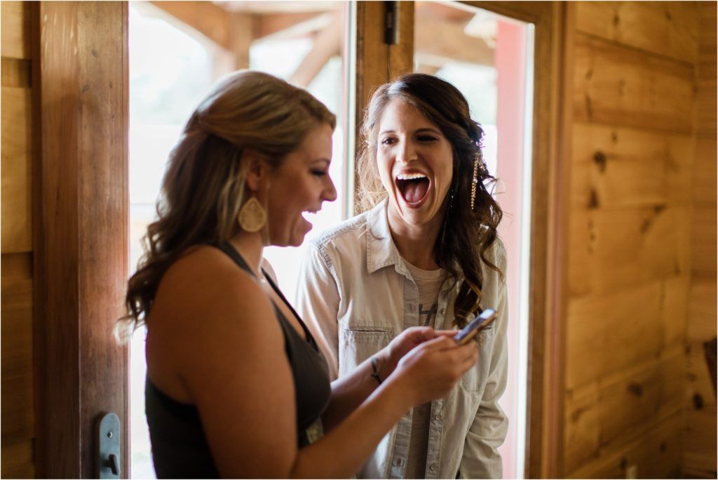 Joyful candid laughter shared during wedding day preparations.