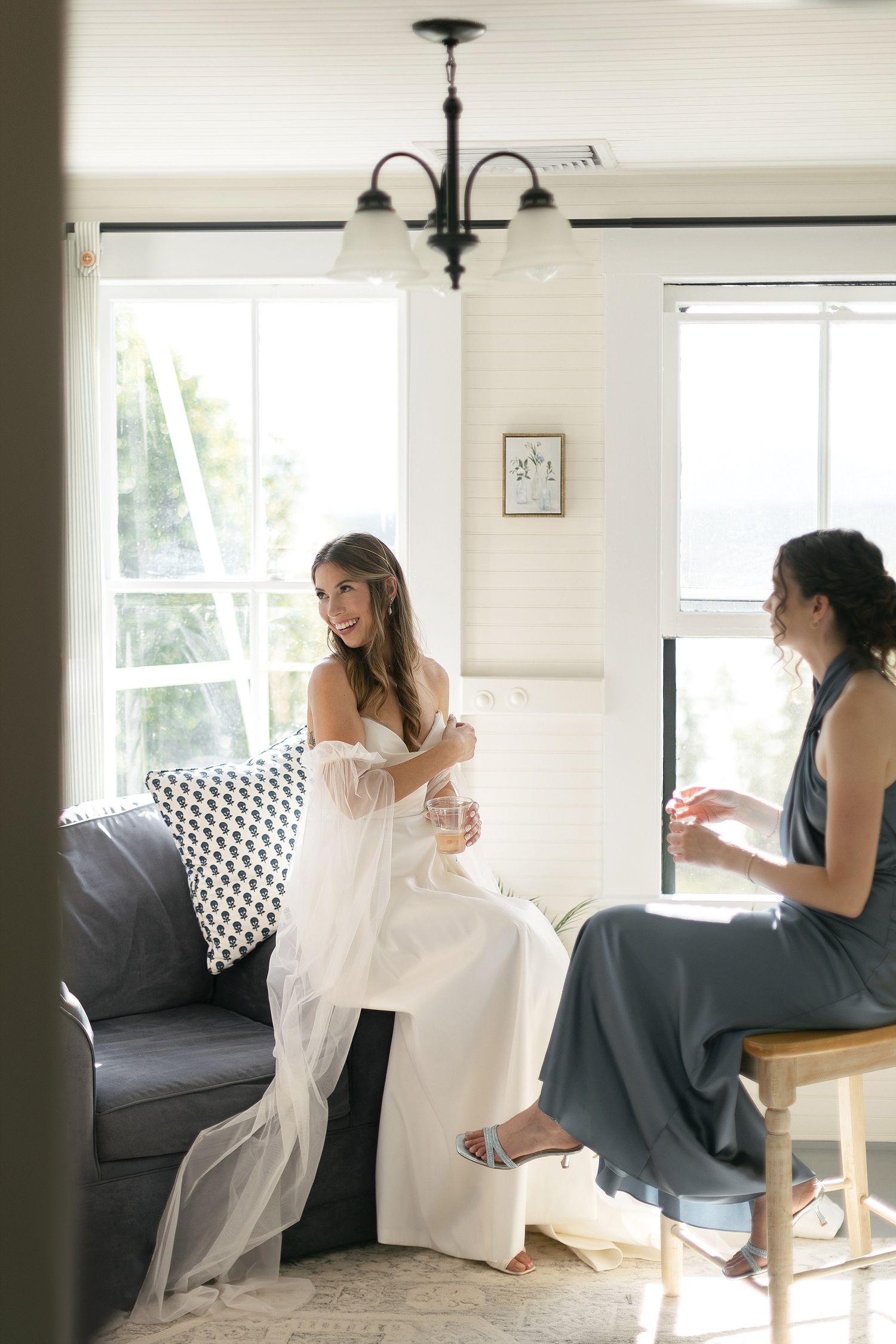 A candid moment of wedding preparation in a bright, modern room with white decor.