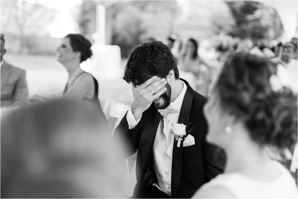 Black and white photo of an emotional moment at a wedding reception showing raw feelings.