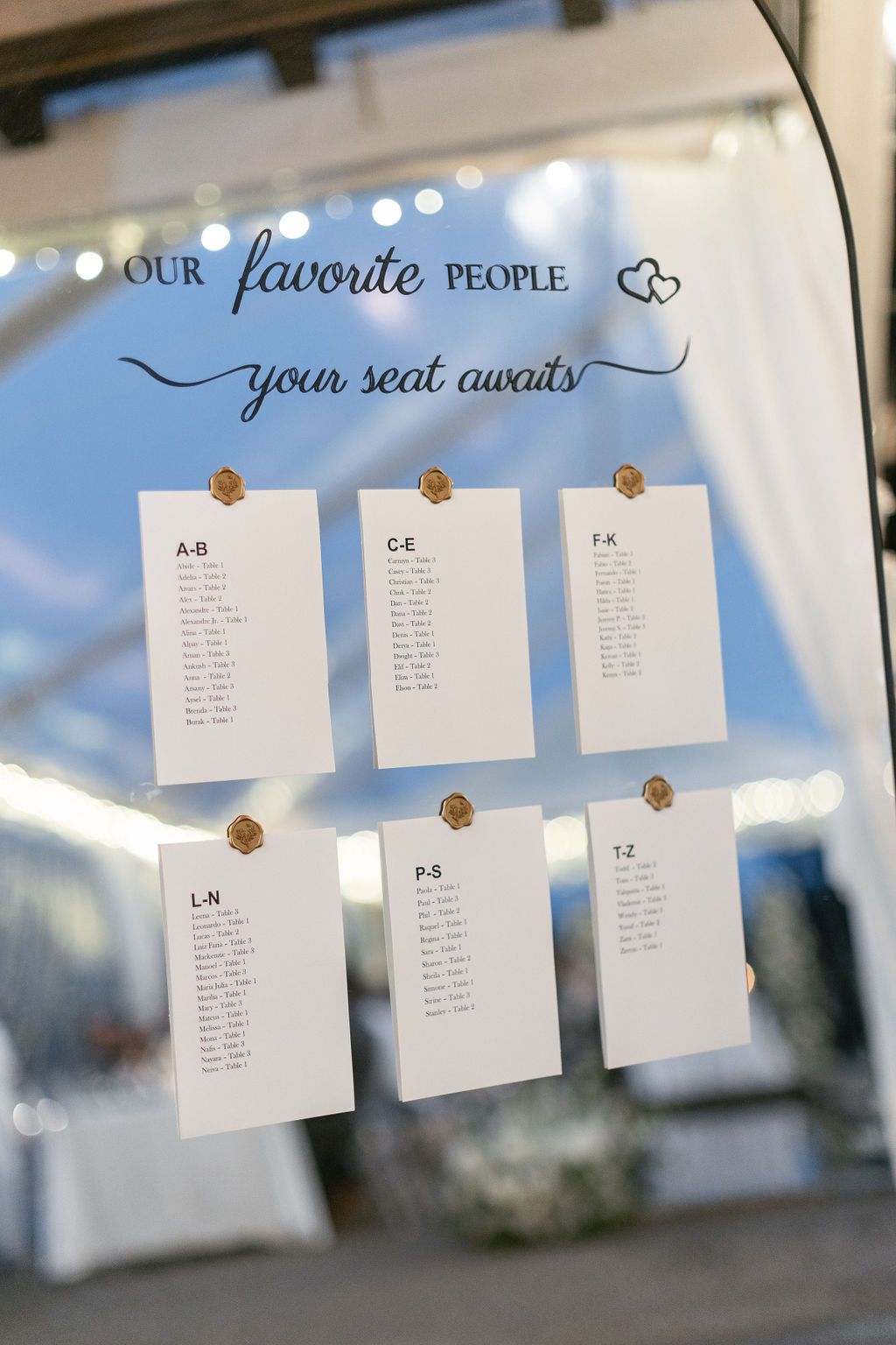 Elegant mirror seating chart display with 'Our Favorite People' header and organized table assignments.