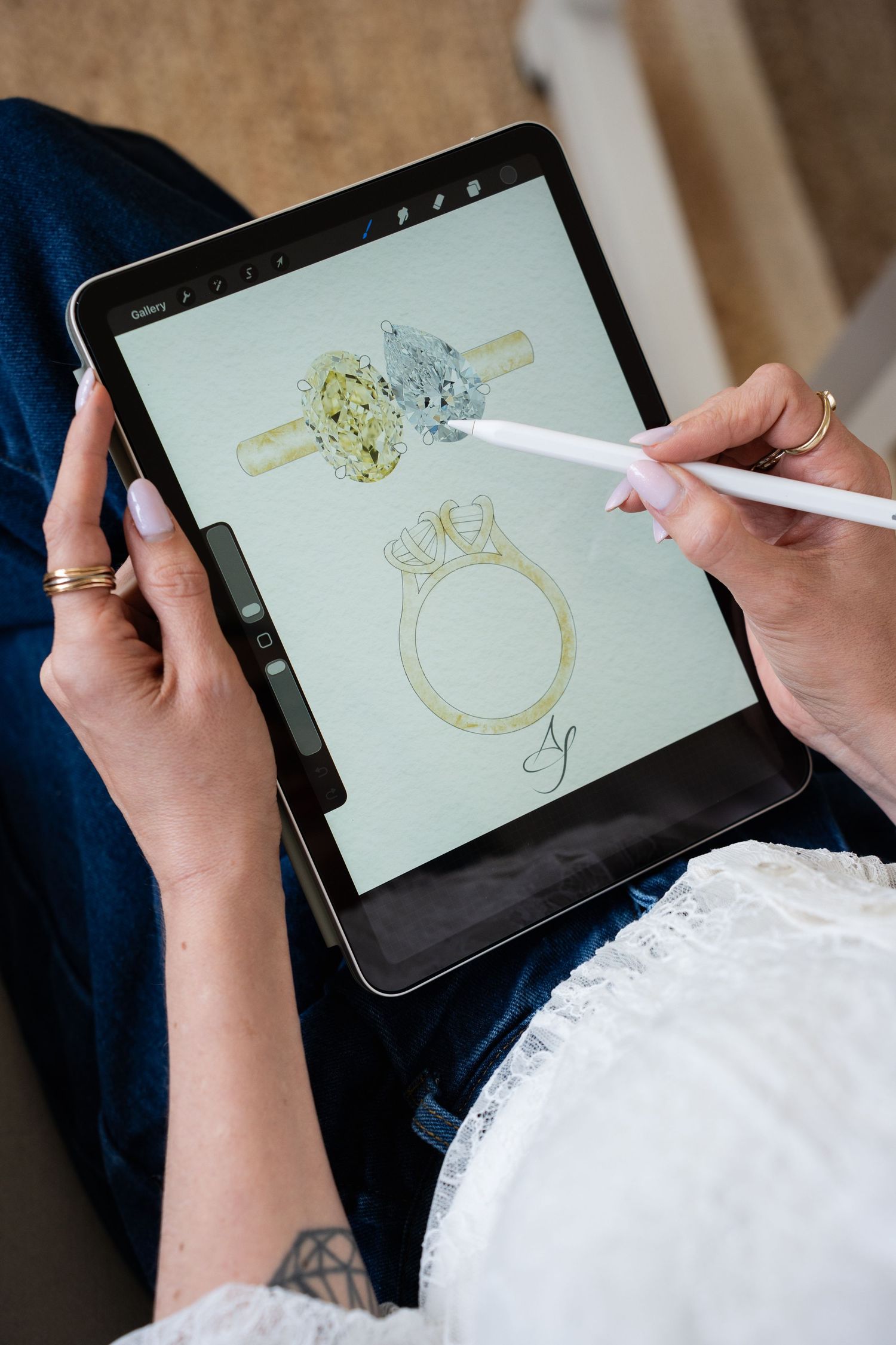Artist using Apple Pencil on iPad to sketch elegant diamond engagement ring designs in digital art app.