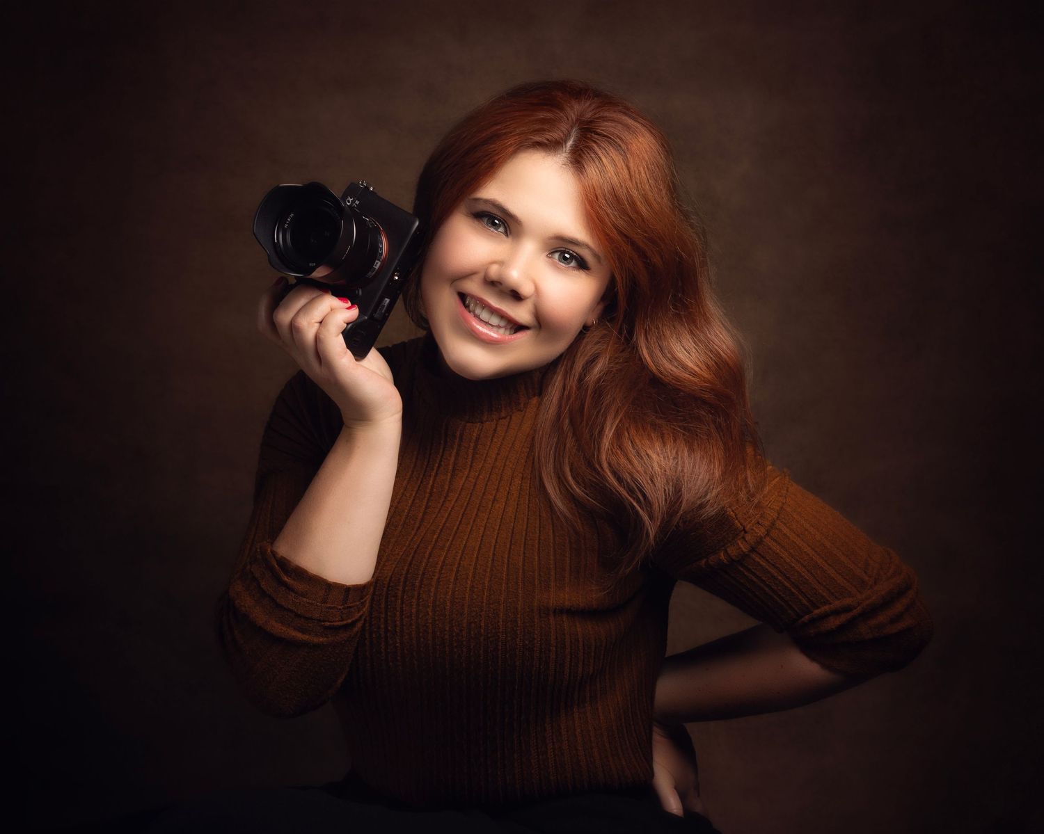 Gemma Harte holding a professional camera in a studio portrait in the West Midlands