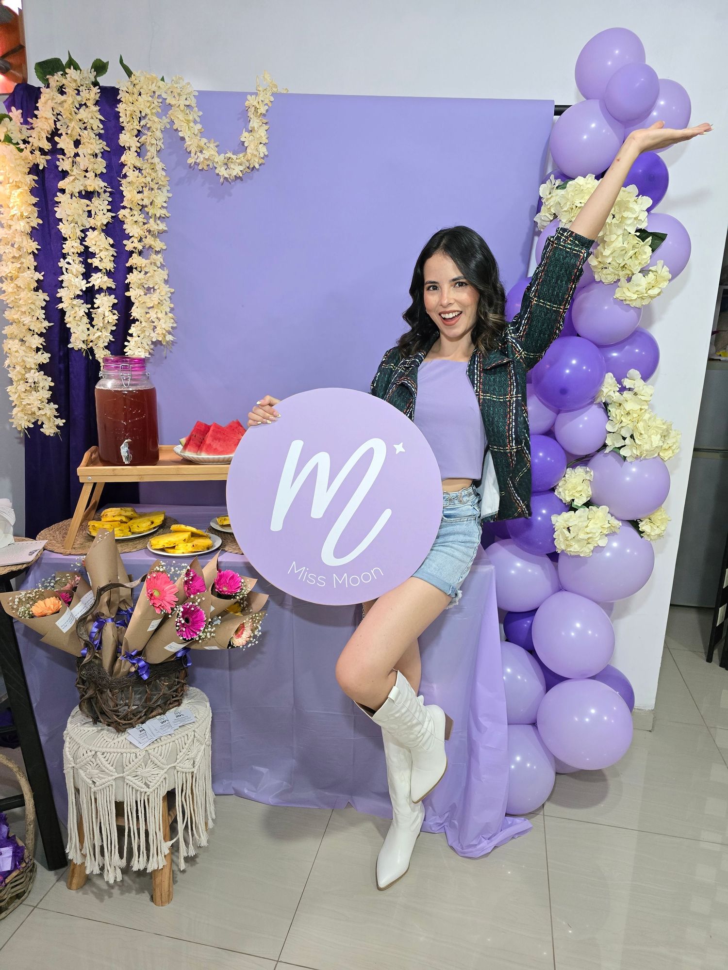 Purple balloon arch and floral decor surrounding Miss Moon branded event setup.