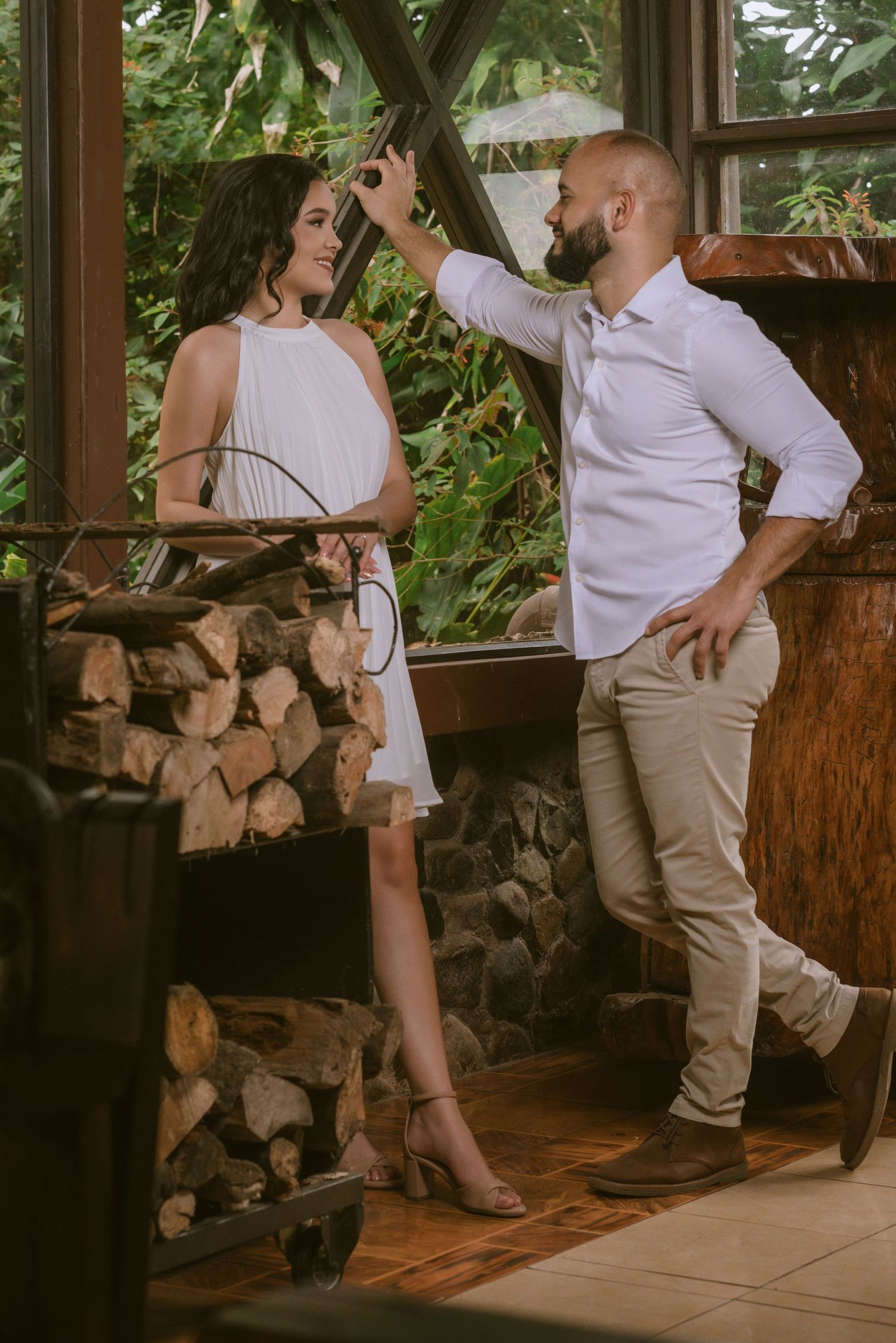 A playful couple poses in a rustic indoor setting with wooden decor.