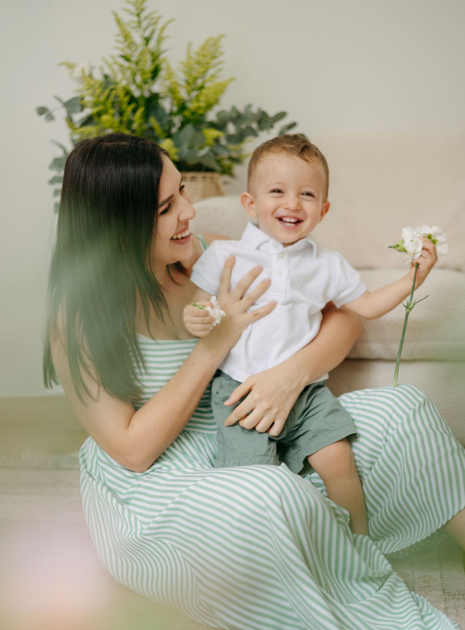 Candid family portrait showing genuine laughter and connection in a light-filled room.