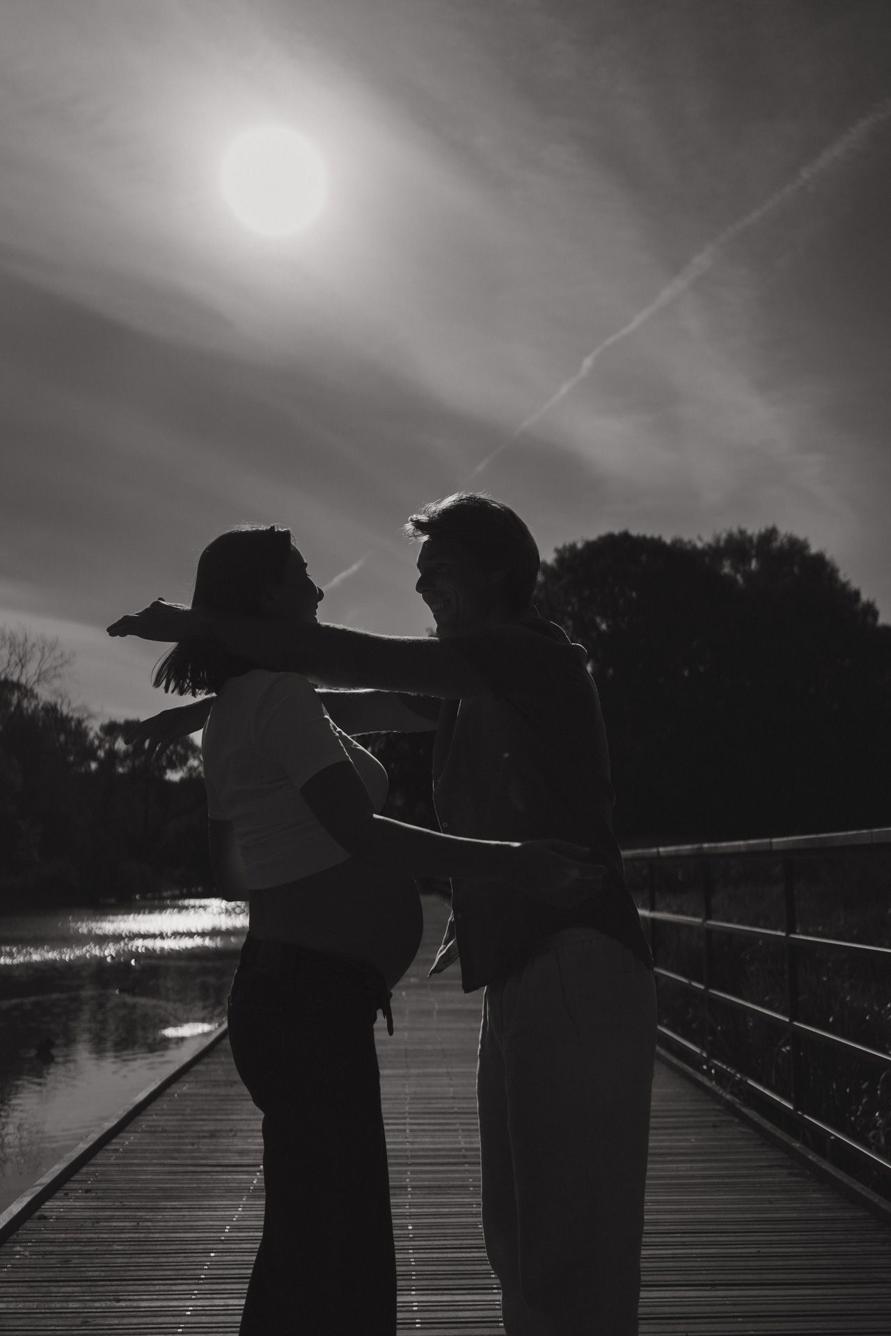 Silhouet van een zwanger koppel tijdens een zwangerschapsshoot in een park in Mechelen