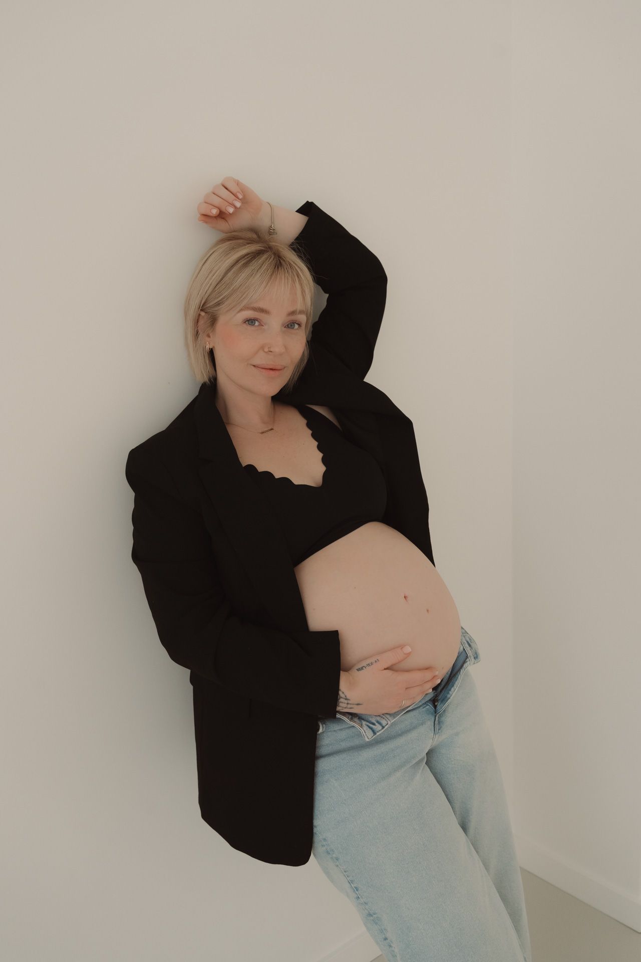 Zwangere vrouw poseert met zichtbare babybuik tijdens een zwangerschapsshoot in de studio