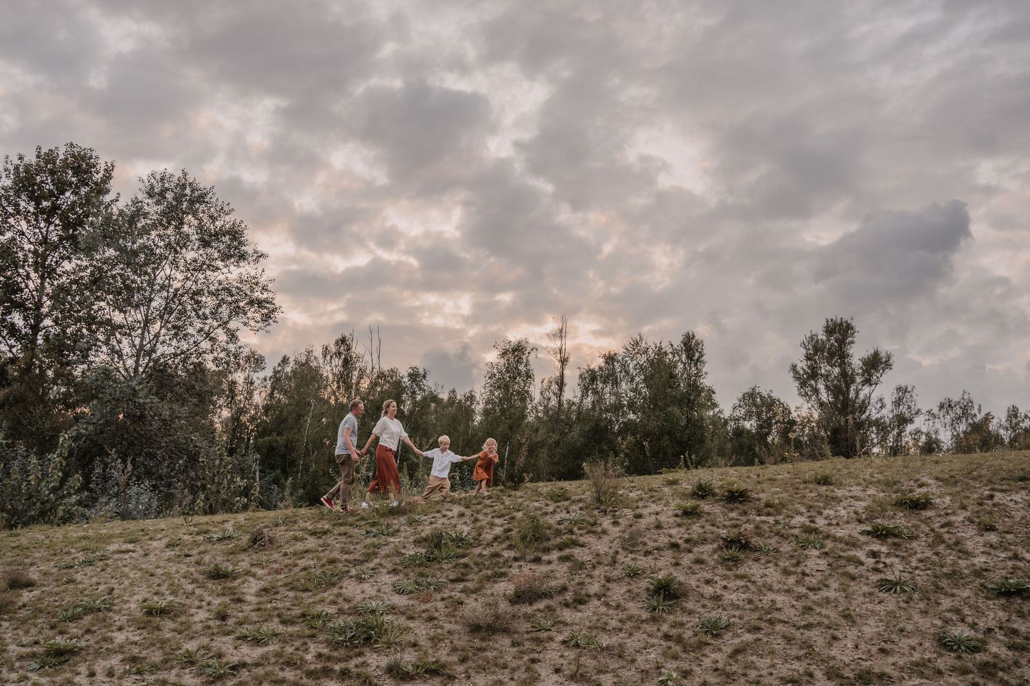 Gezin wandelt samen door de natuur tijdens een ontspannen gezinsshoot
