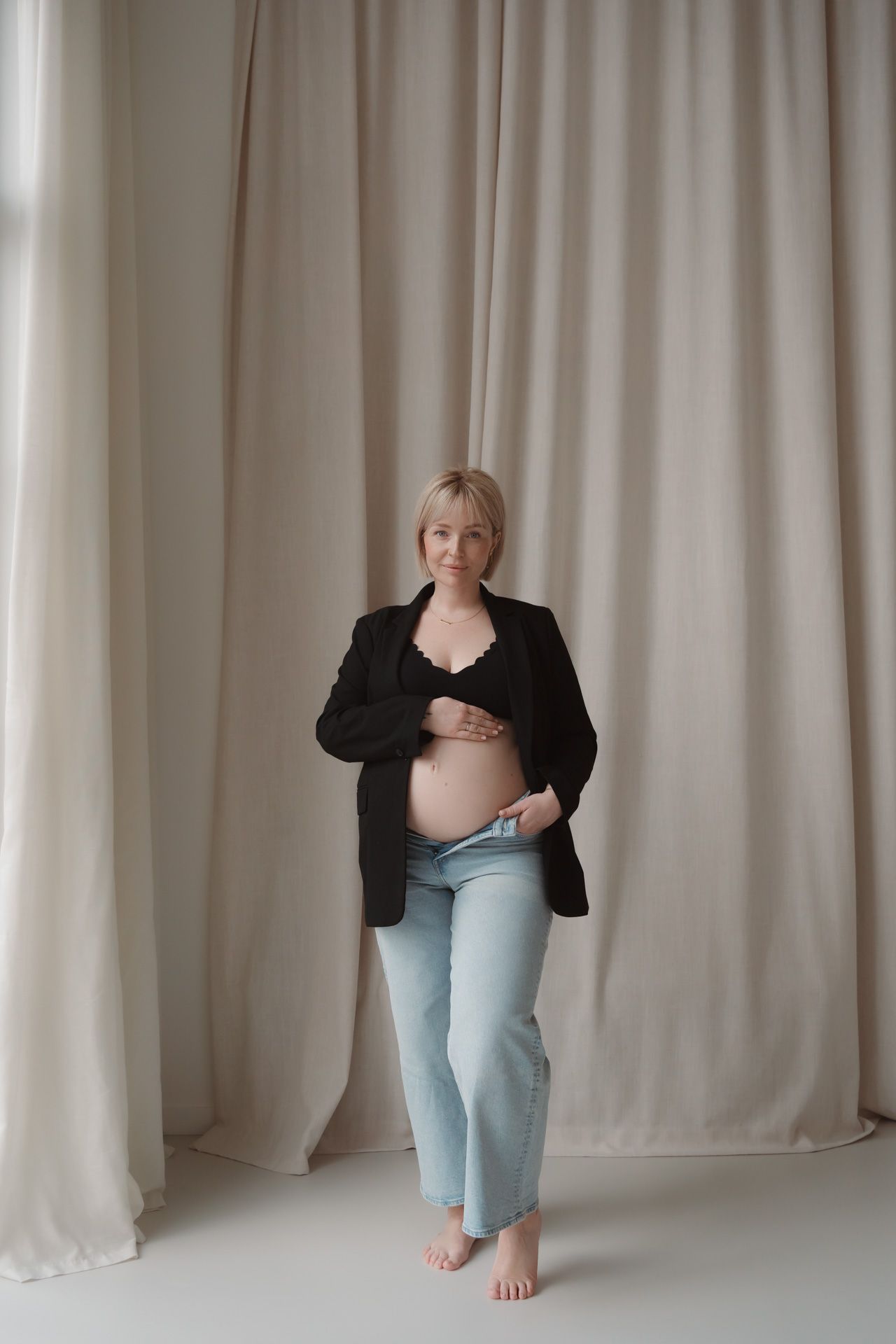 Zwangere vrouw met zichtbare babybuik tijdens een stijlvolle zwangerschapsshoot in de studio