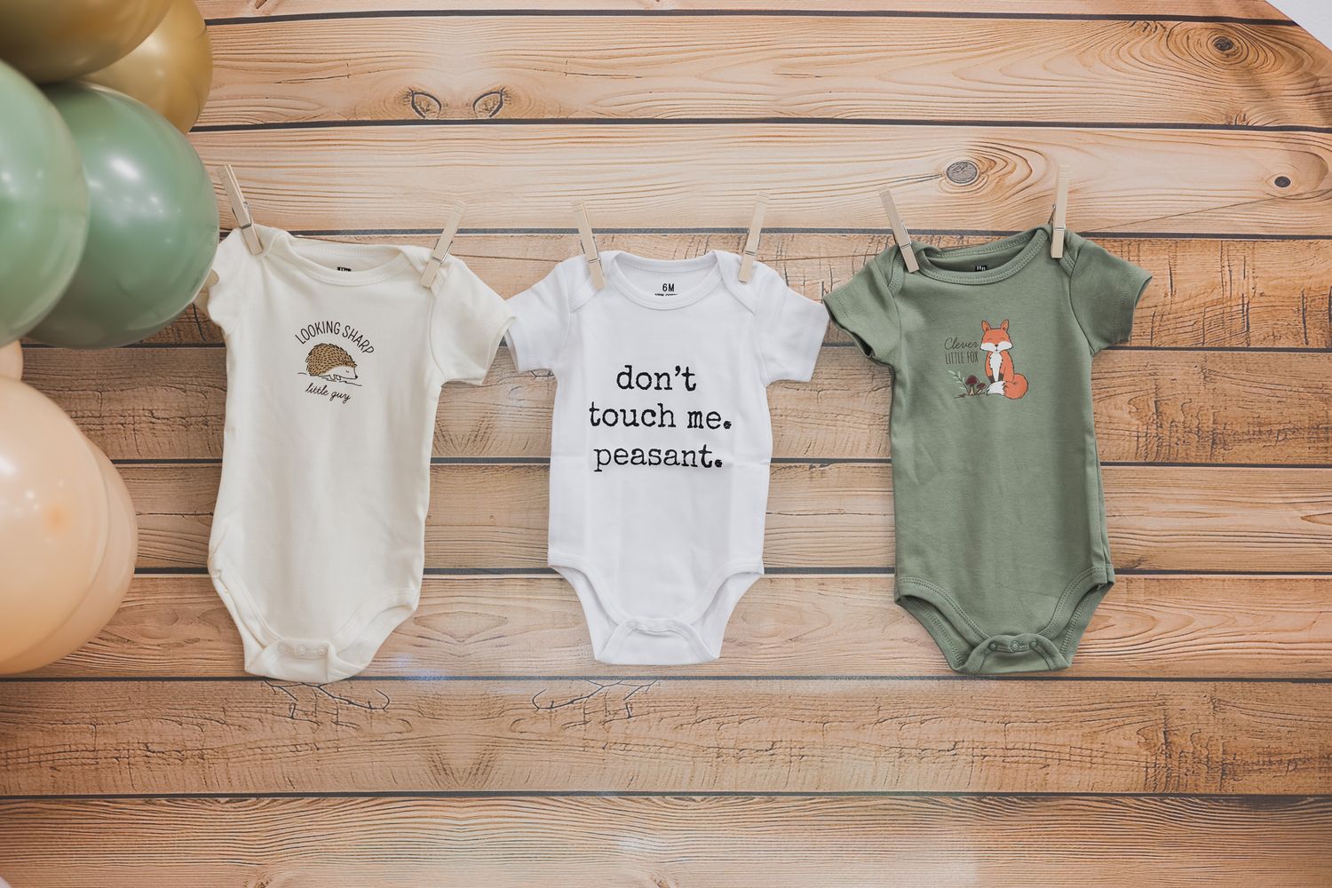 Baby onesies hanging on a clothesline display at a baby shower