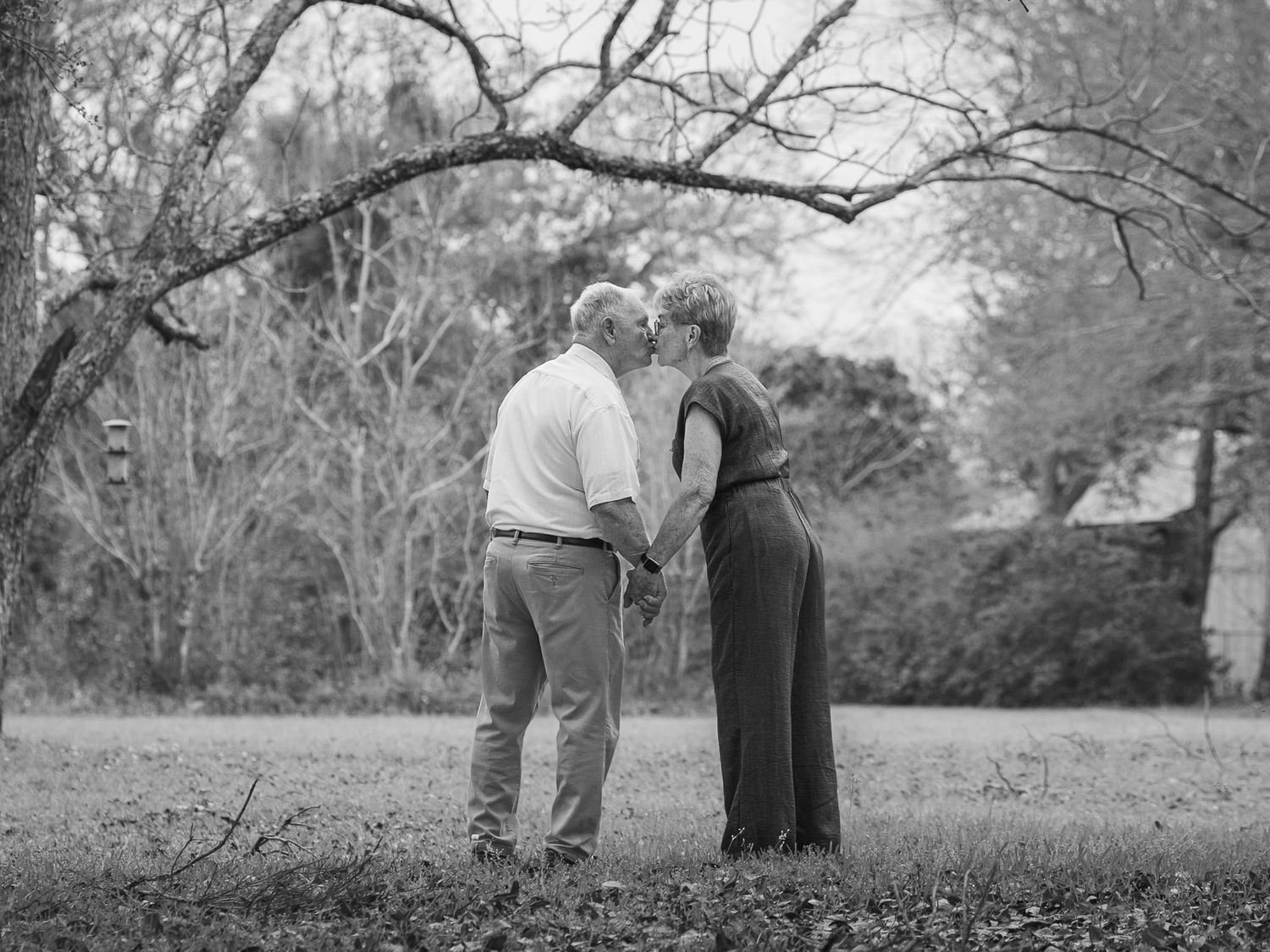 Black and white photo of grandparents standing together in their yard in Pensacola, FL